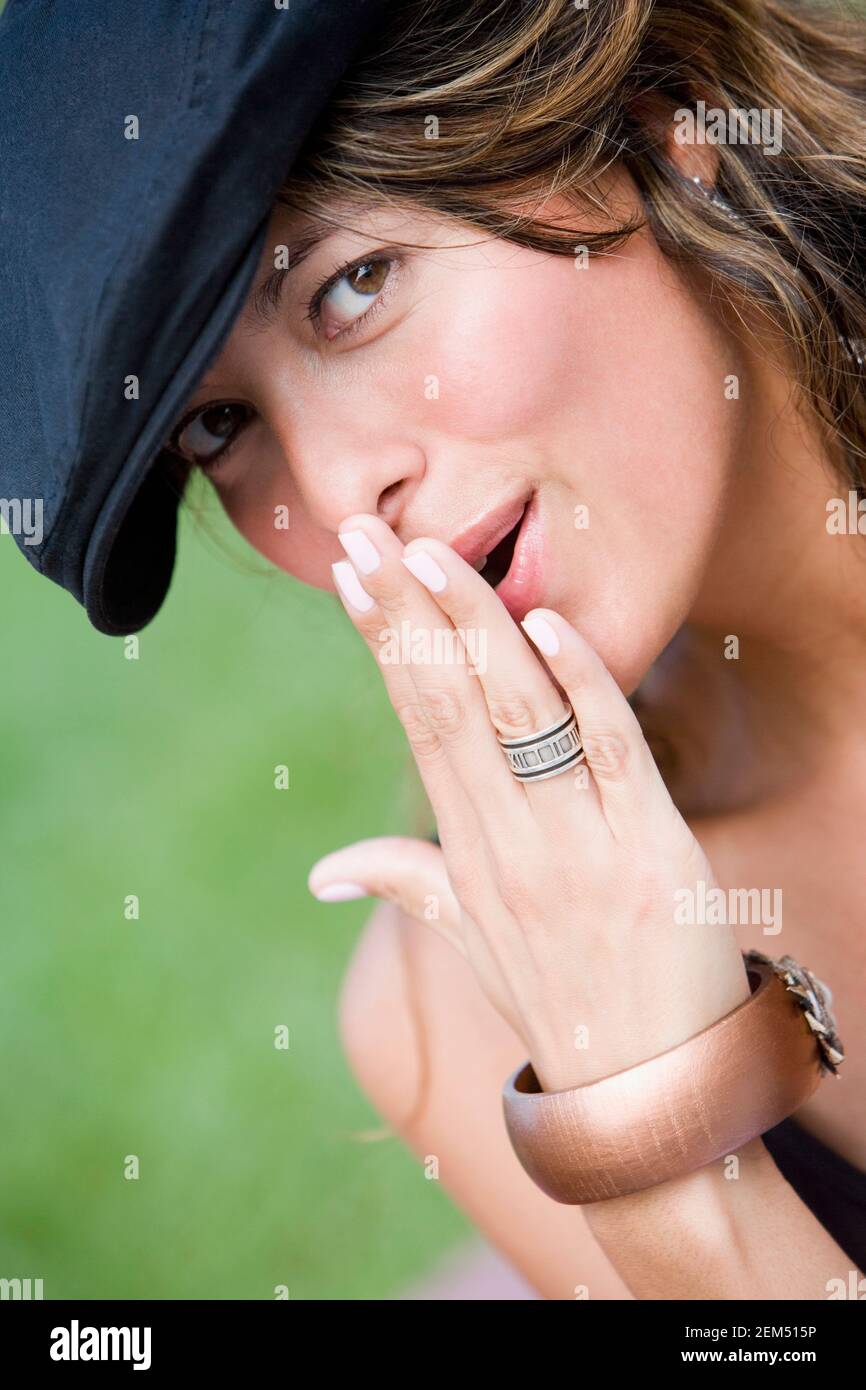 Ritratto di una giovane donna sorridente con la mano sopra la sua bocca Foto Stock
