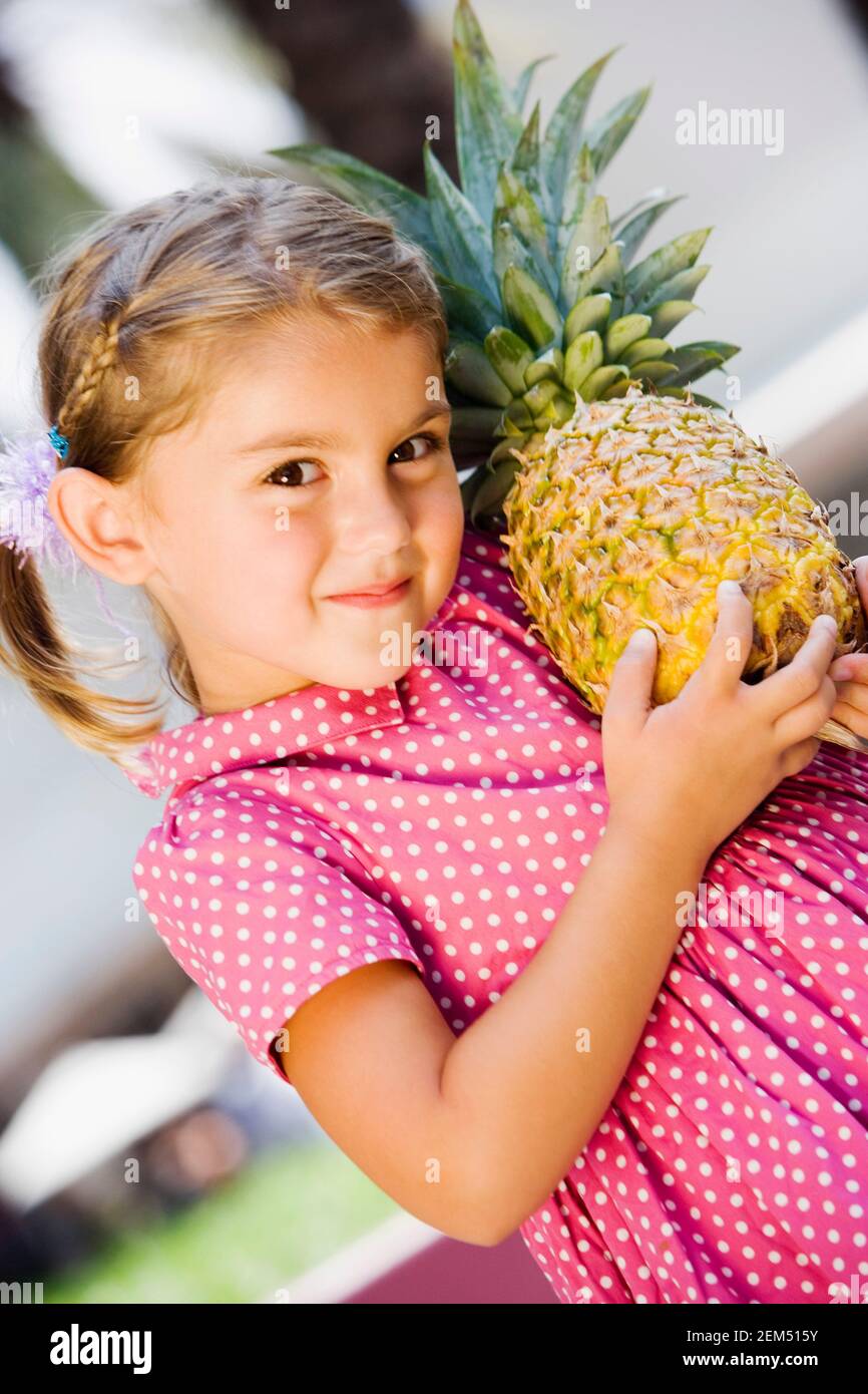 Ritratto di una ragazza che tiene un ananas Foto Stock
