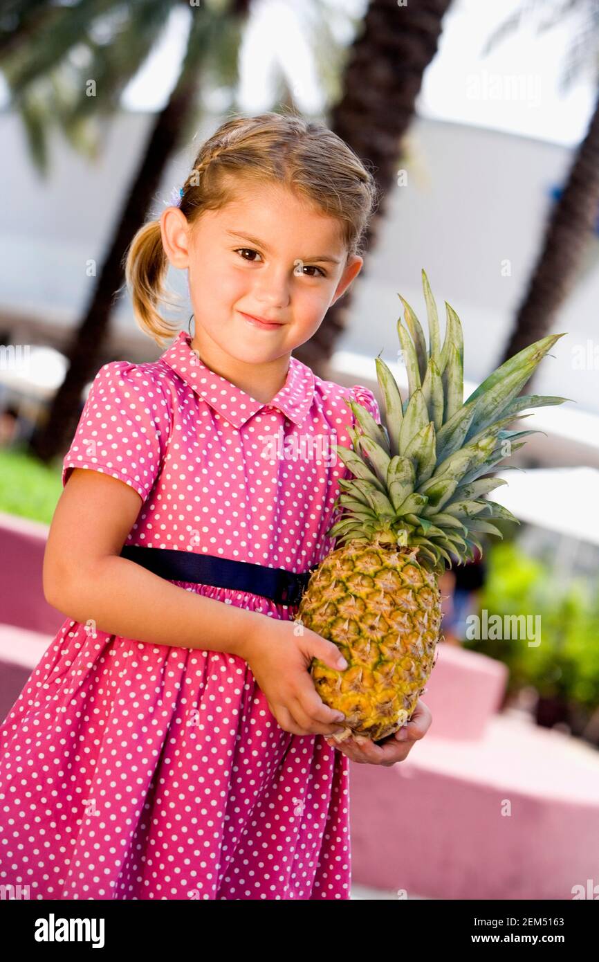Ritratto di una ragazza che tiene un ananas Foto Stock