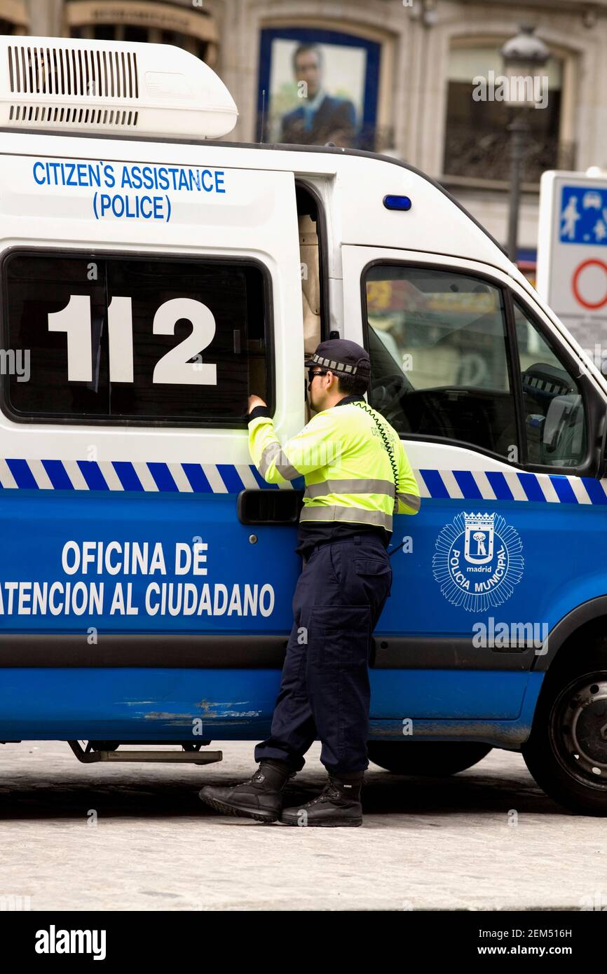 Vista posteriore di un uomo che guarda all'interno di un pulmino di polizia, Madrid, Spagna Foto Stock