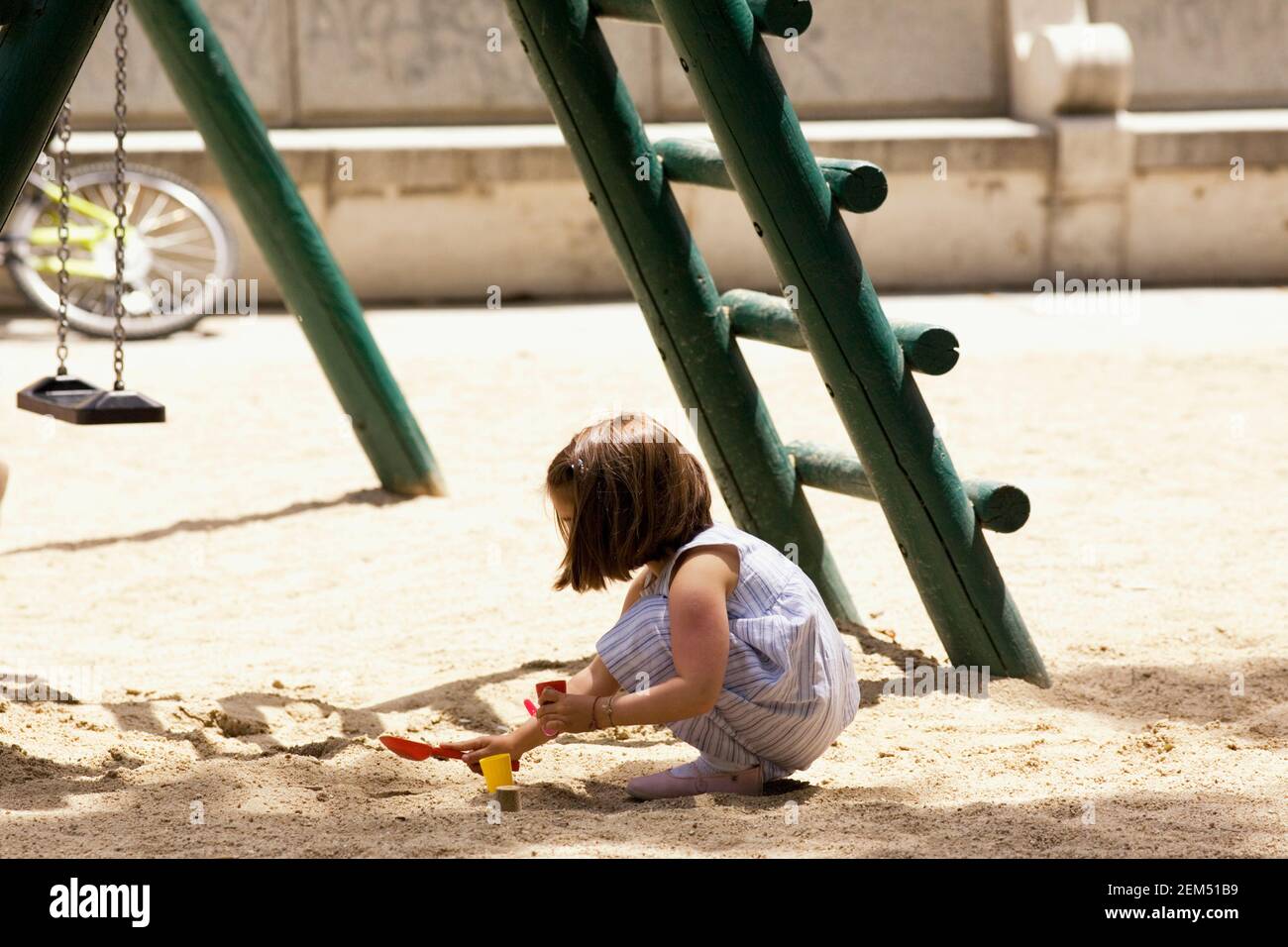 Profilo laterale di una ragazza che gioca con la sabbia nel parco, Madrid, Spagna Foto Stock