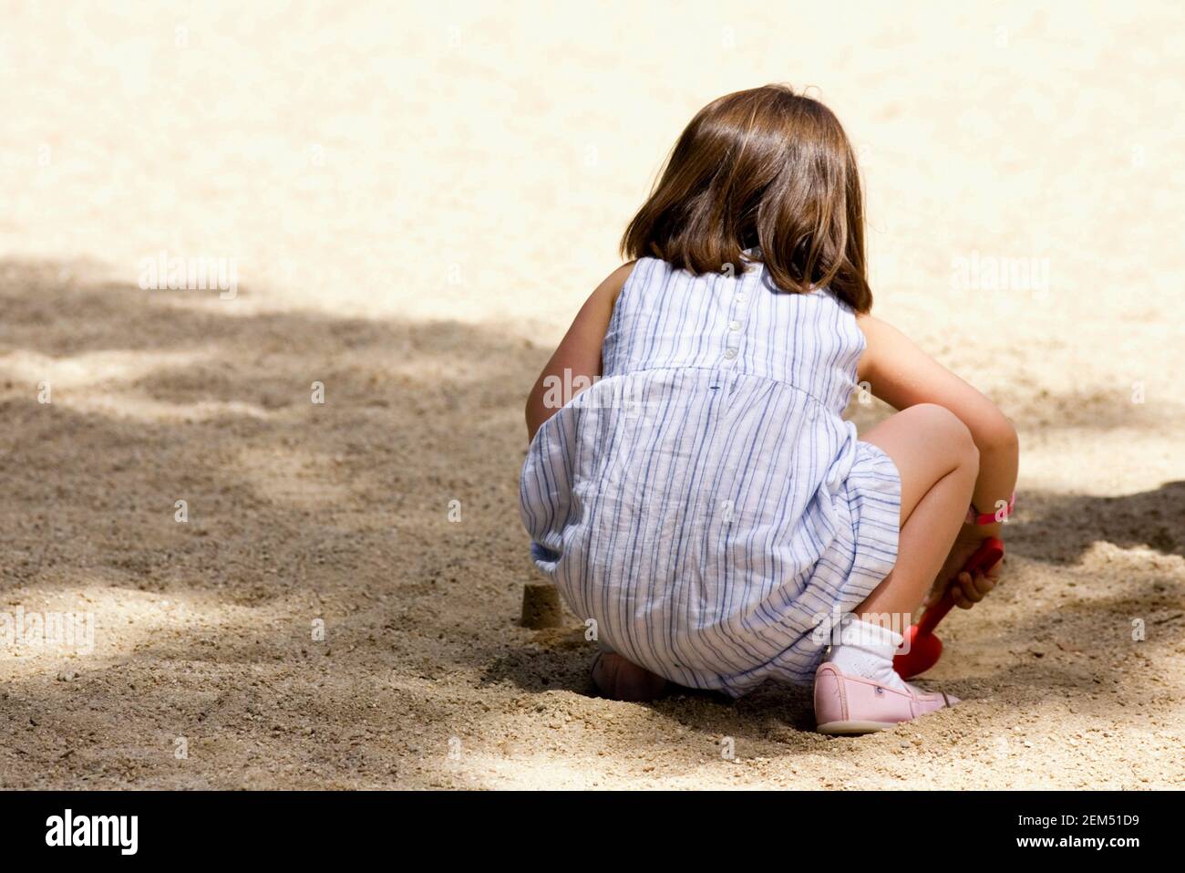 Vista posteriore di una ragazza che gioca nella sabbia, Madrid, Spagna Foto Stock