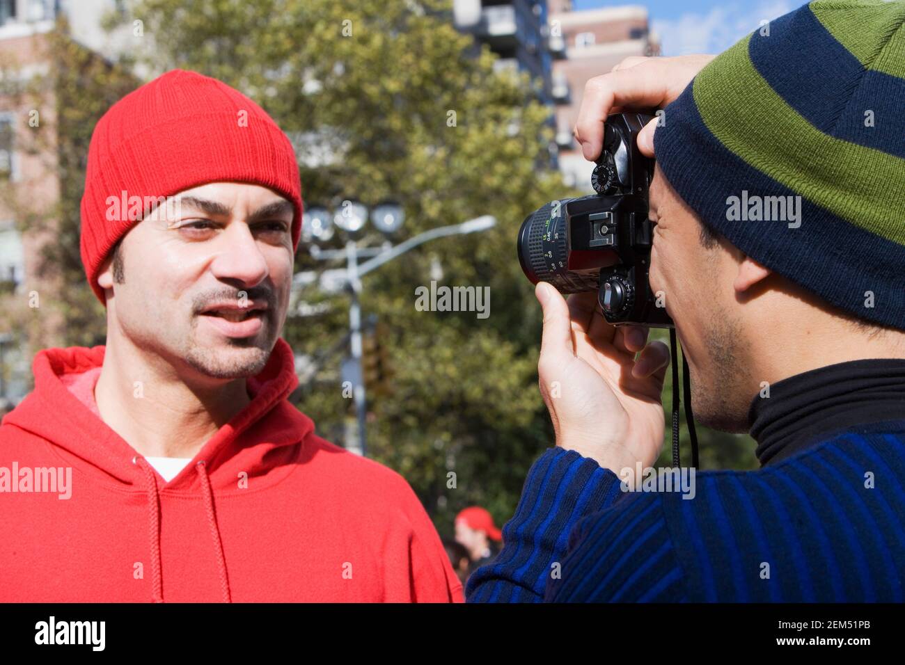 Vista posteriore di un uomo medio adulto che scattano una foto di un uomo Foto Stock