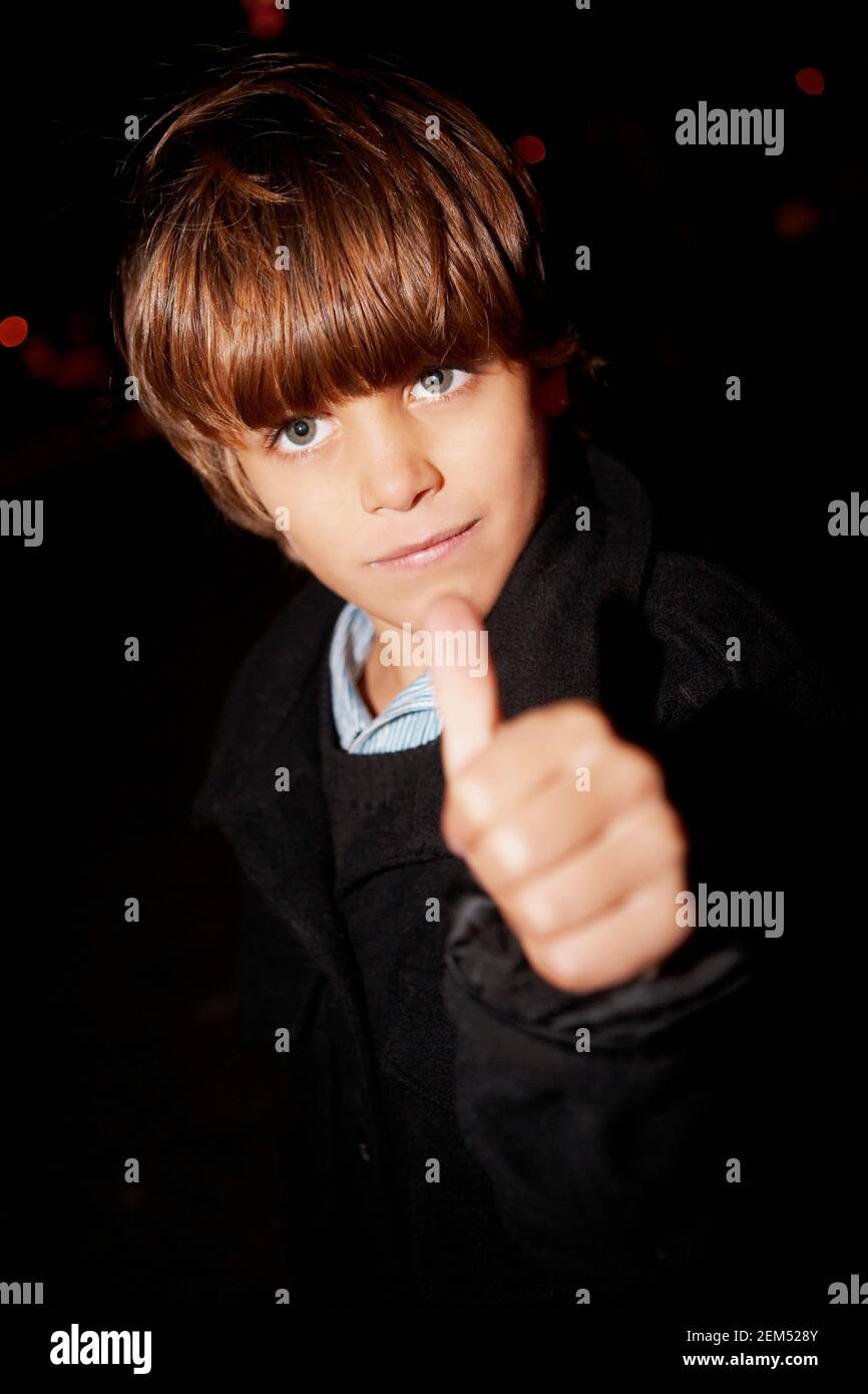 Ritratto di un ragazzo che mostra un segno dei pollici Foto Stock