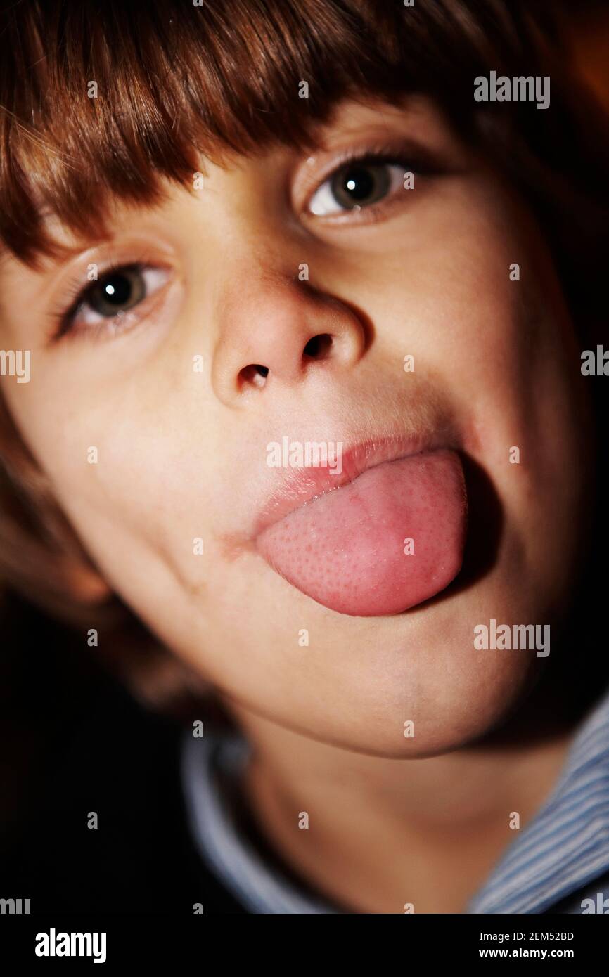 Ritratto di un ragazzo il suo incollaggio con la lingua fuori Foto Stock