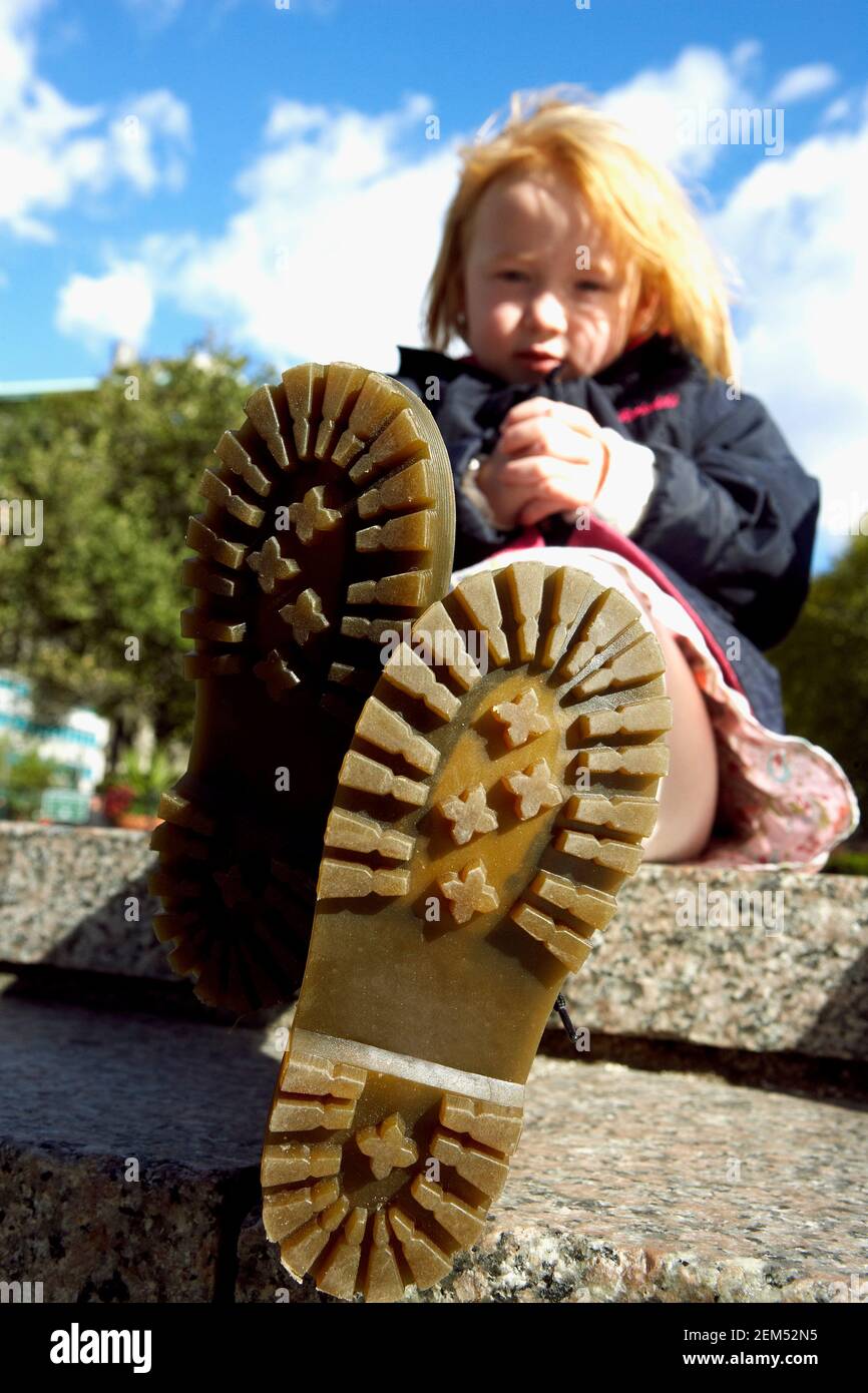 Ritratto di una ragazza che mostra la suola delle sue scarpe Foto stock -  Alamy