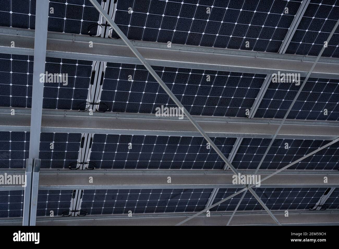 Una vista dal basso di un sistema di pannelli solari costruito su travi metalliche in acciaio in Airdrie Alberta Canada. Foto Stock