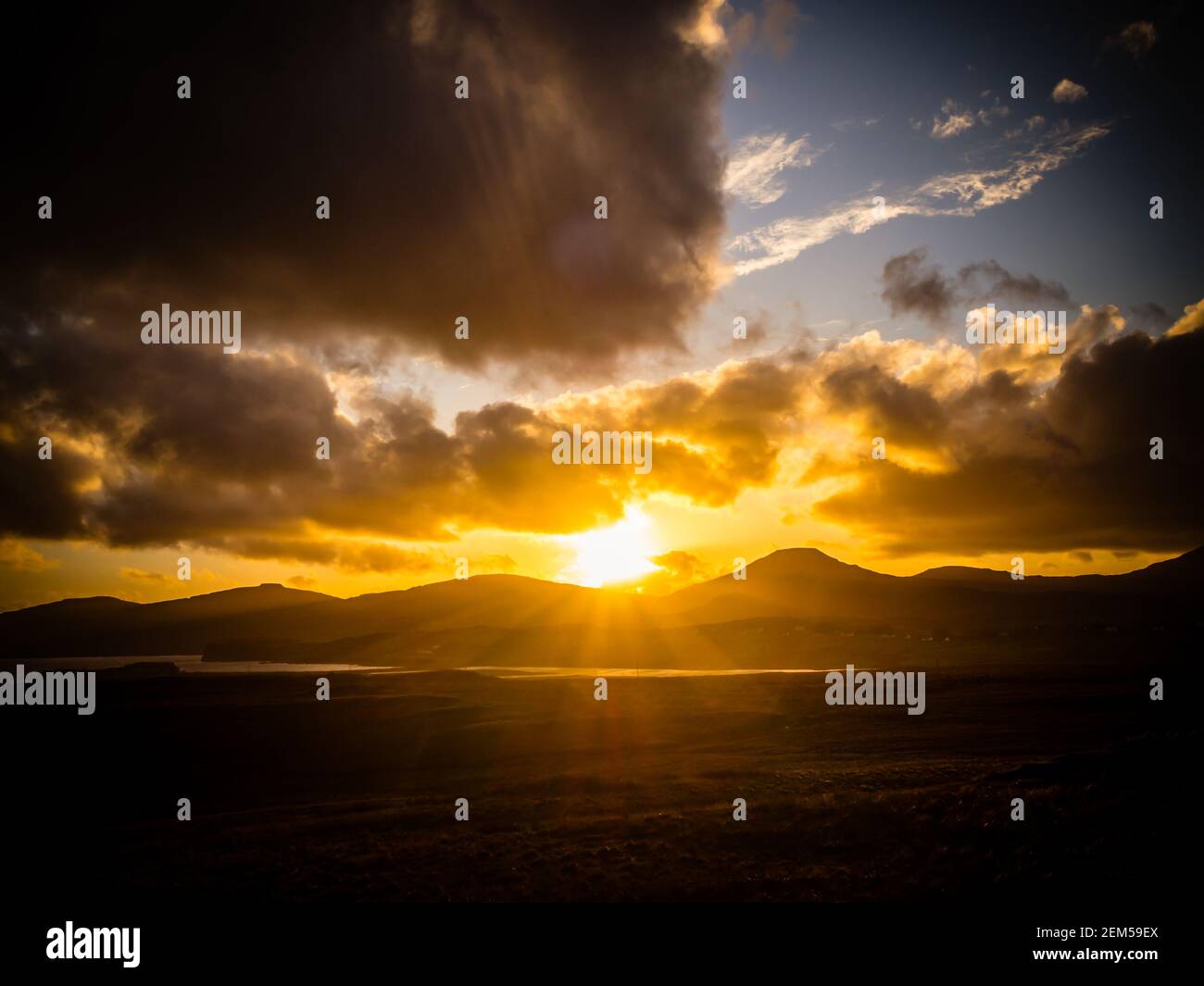 Tramonto sull'isola di Skye con una tempesta in alto e raggi solari che si infrangono Foto Stock