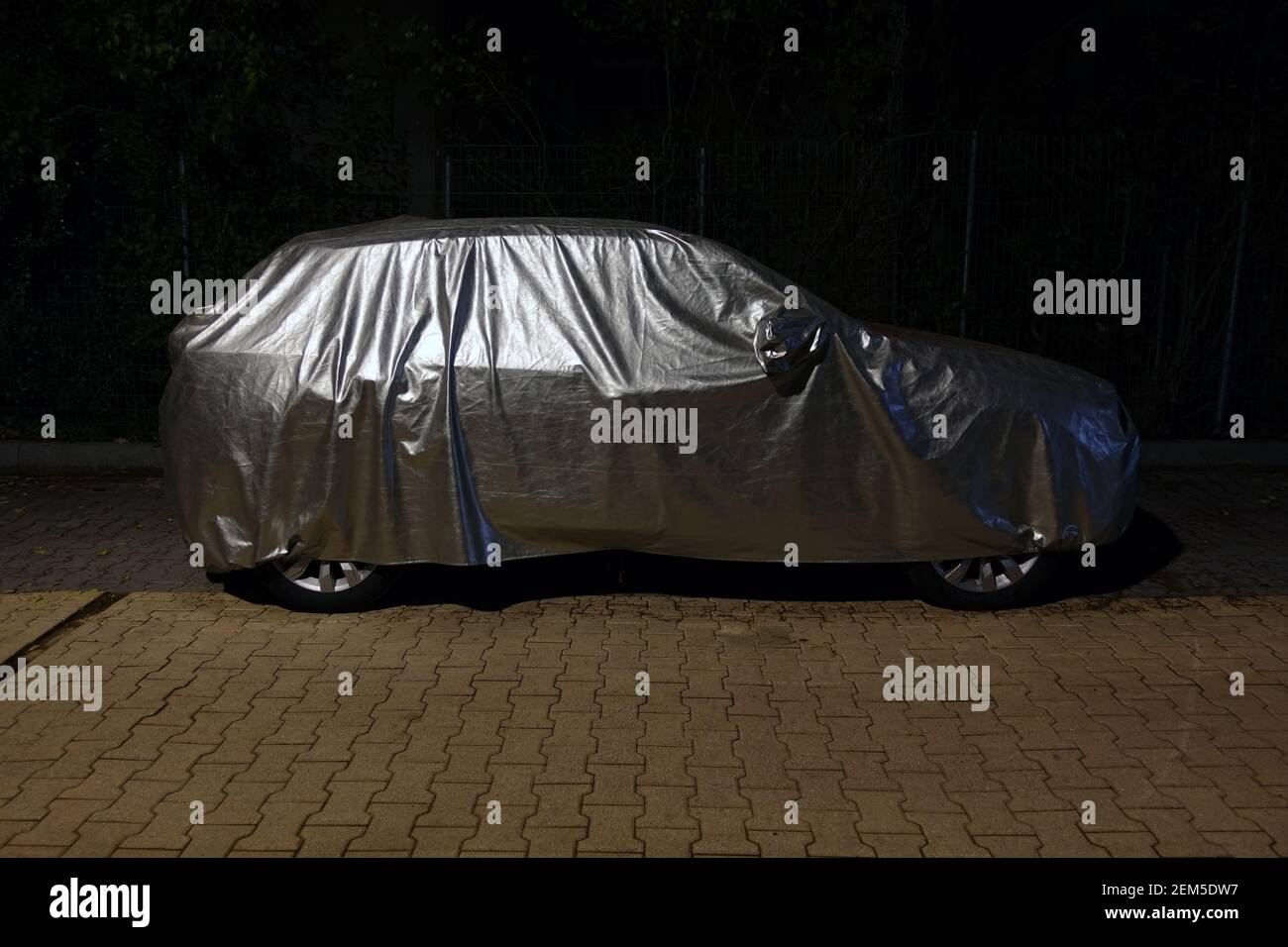 Auto con copertura protettiva in argento di notte. Foto Stock