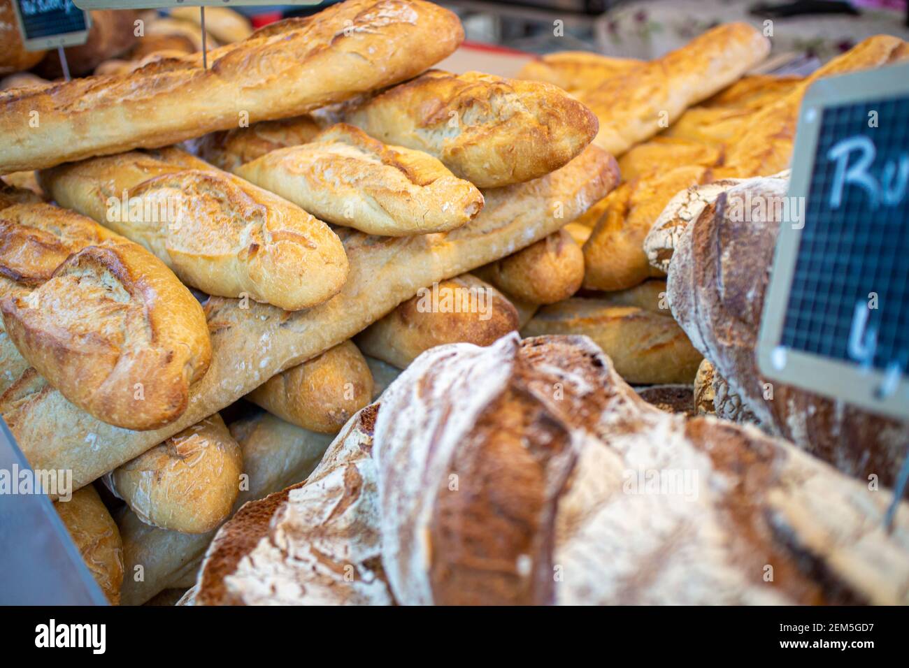 Baguette e altri tipi di pane esposti in un mercato gourmet con Prodotti francesi Foto Stock