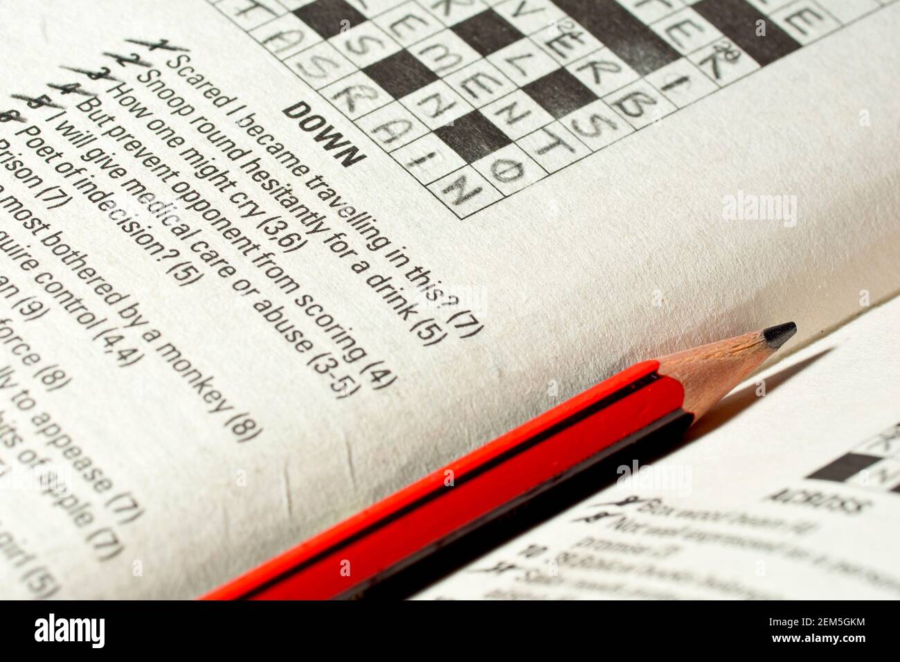 Un primo piano di una matita giacente su un libro di puzzle di crossword, la stessa crossword finito. Concetto di fare una pausa. Foto Stock