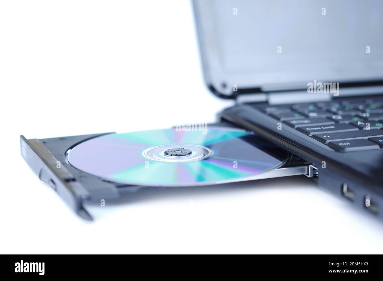 Computer portatile con un DVD su disco nel vassoio Foto Stock