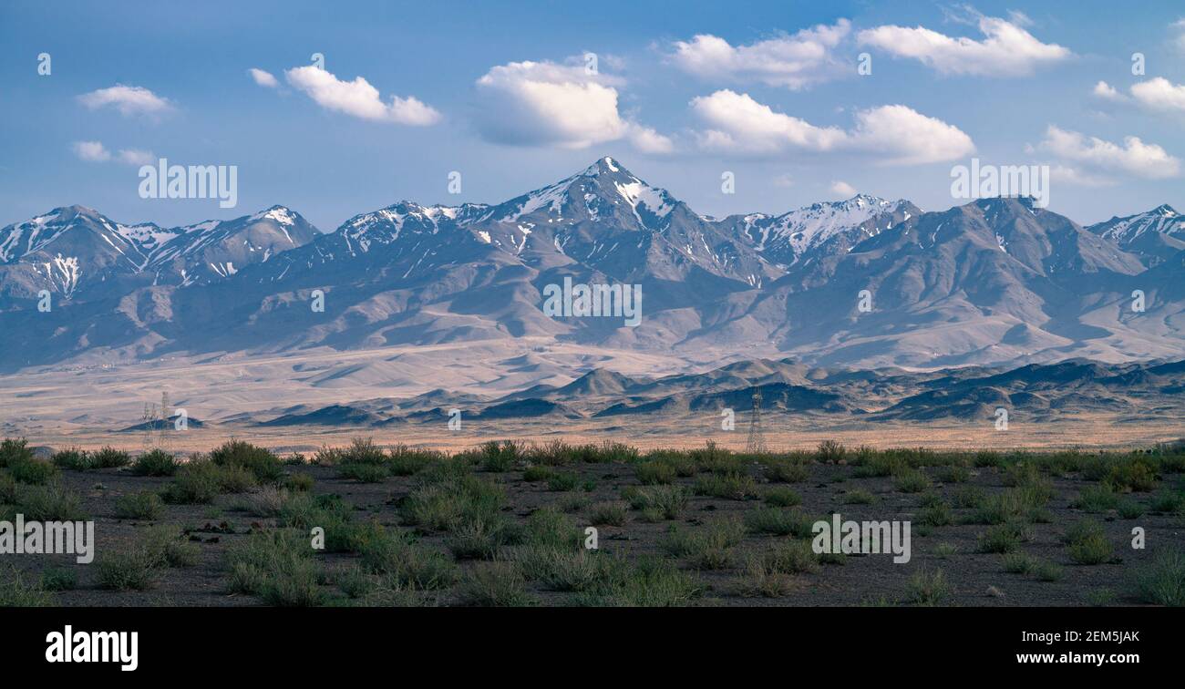 Alte montagne con neve in cima al deserto iraniano. Maestosi quattro millesimi in una morbida foschia in una giornata di sole nell'antica Persia, Iran. Foto Stock