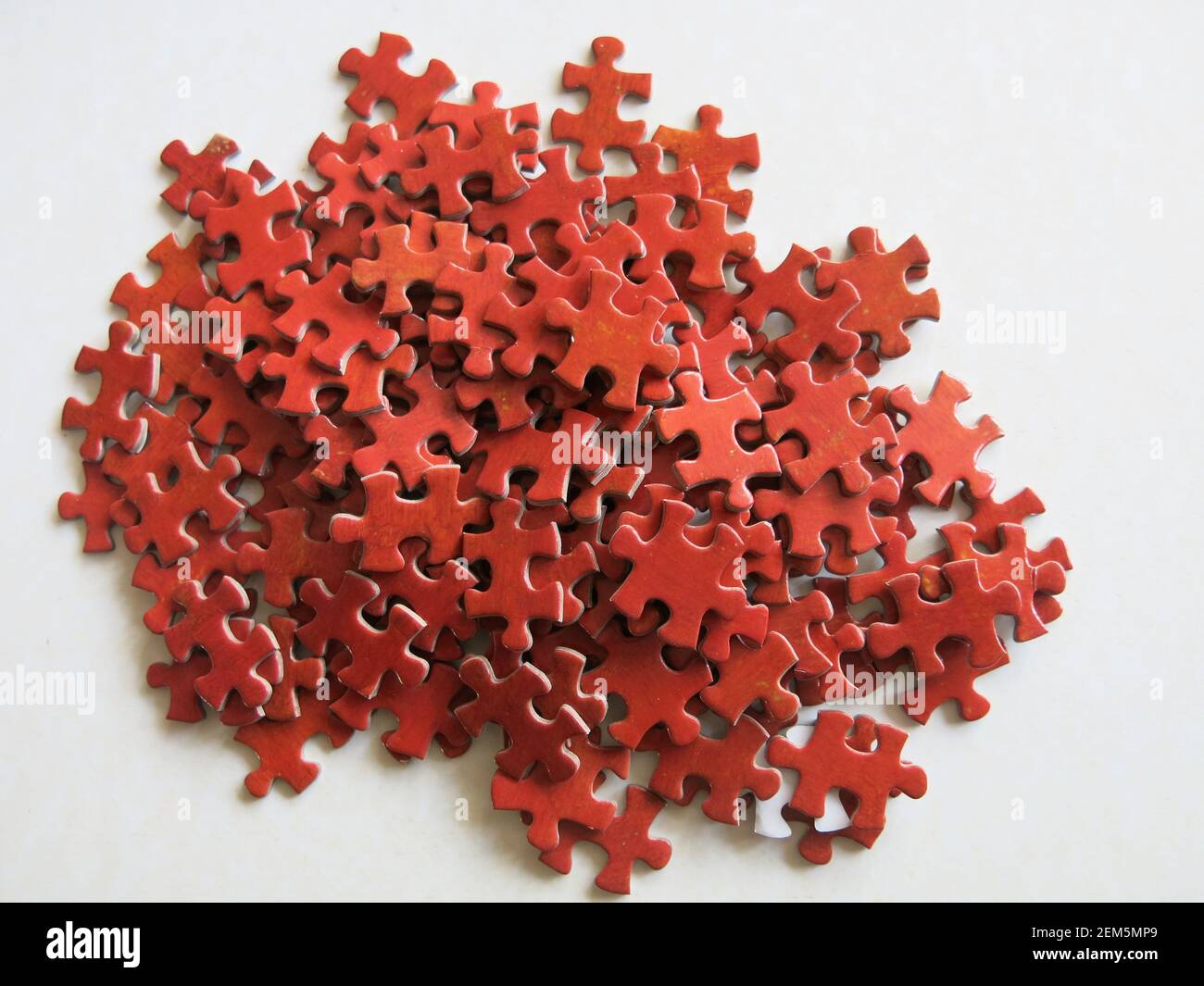 Per il puzzle fanatico; un mucchio di pezzi rossi che tutti sembrano identici. Foto Stock