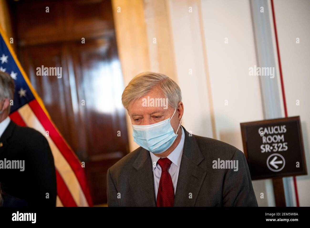 Il senatore degli Stati Uniti Lindsey Graham (repubblicano della Carolina del Sud) ascolta mentre il senatore degli Stati Uniti John Barrasso (repubblicano del Wyoming), offre osservazioni durante una conferenza stampa riguardo ad un aumento del salario minimo a seguito del pranzo della GOP del Senato nella Russell Senate Office Building a Capitol Hill a Washington, DC, Mercoledì, 24 febbraio 2021. Credit: Rod Lamkey/CNP | utilizzo in tutto il mondo Foto Stock