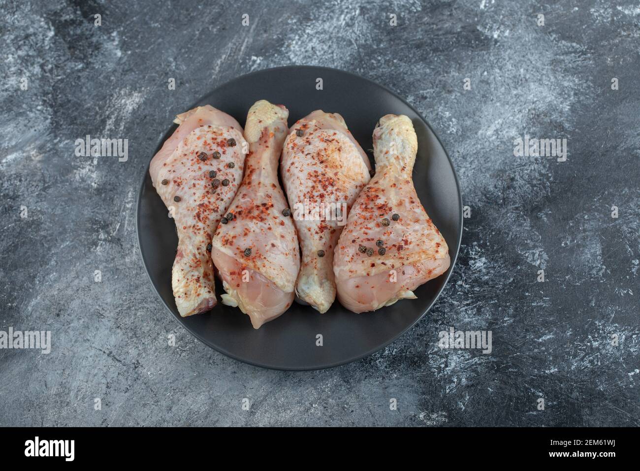 Primo piano foto delle zampe di pollo crudo marinato in grigio sfondo Foto Stock