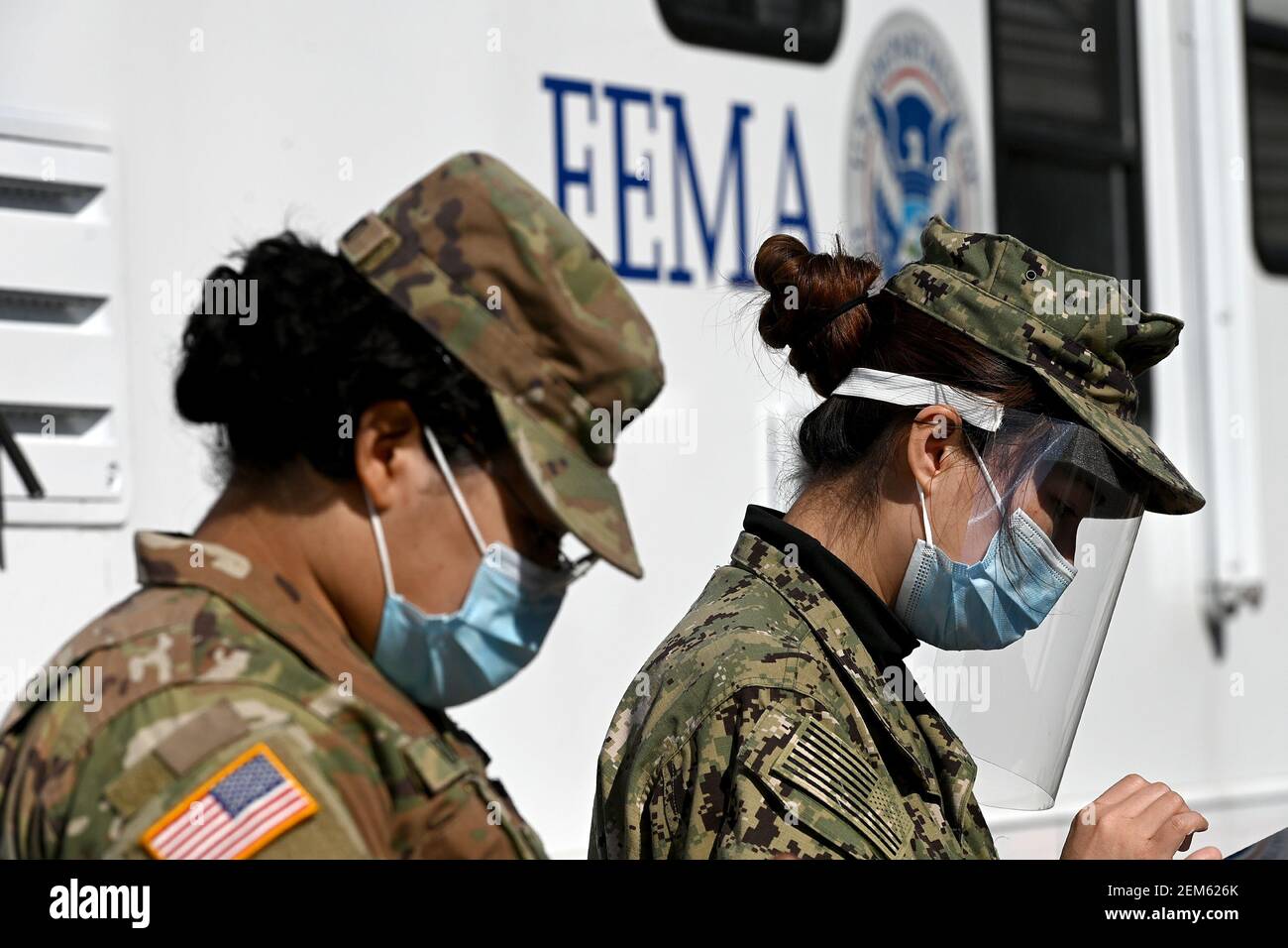 New York, Stati Uniti. 24 Feb 2021. I membri della Guardia Nazionale dell'Esercito e della Riserva della Marina aiutano le persone a registrarsi per gli appuntamenti con il vaccino COVID-19 in un sito di vaccinazione di massa di Stato-FEMA presso lo York College, nel quartiere Queens di New York City, NY, 24 febbraio 2021. L'MTA ha anche annunciato che sta lanciando un servizio di autobus migliorato tra NYCHA e centri comunali per lo York College per un migliore trasporto pubblico ai siti a partire dal 1 marzo. (Foto di Anthony Behar/Sipa USA) Credit: Sipa USA/Alamy Live News Foto Stock