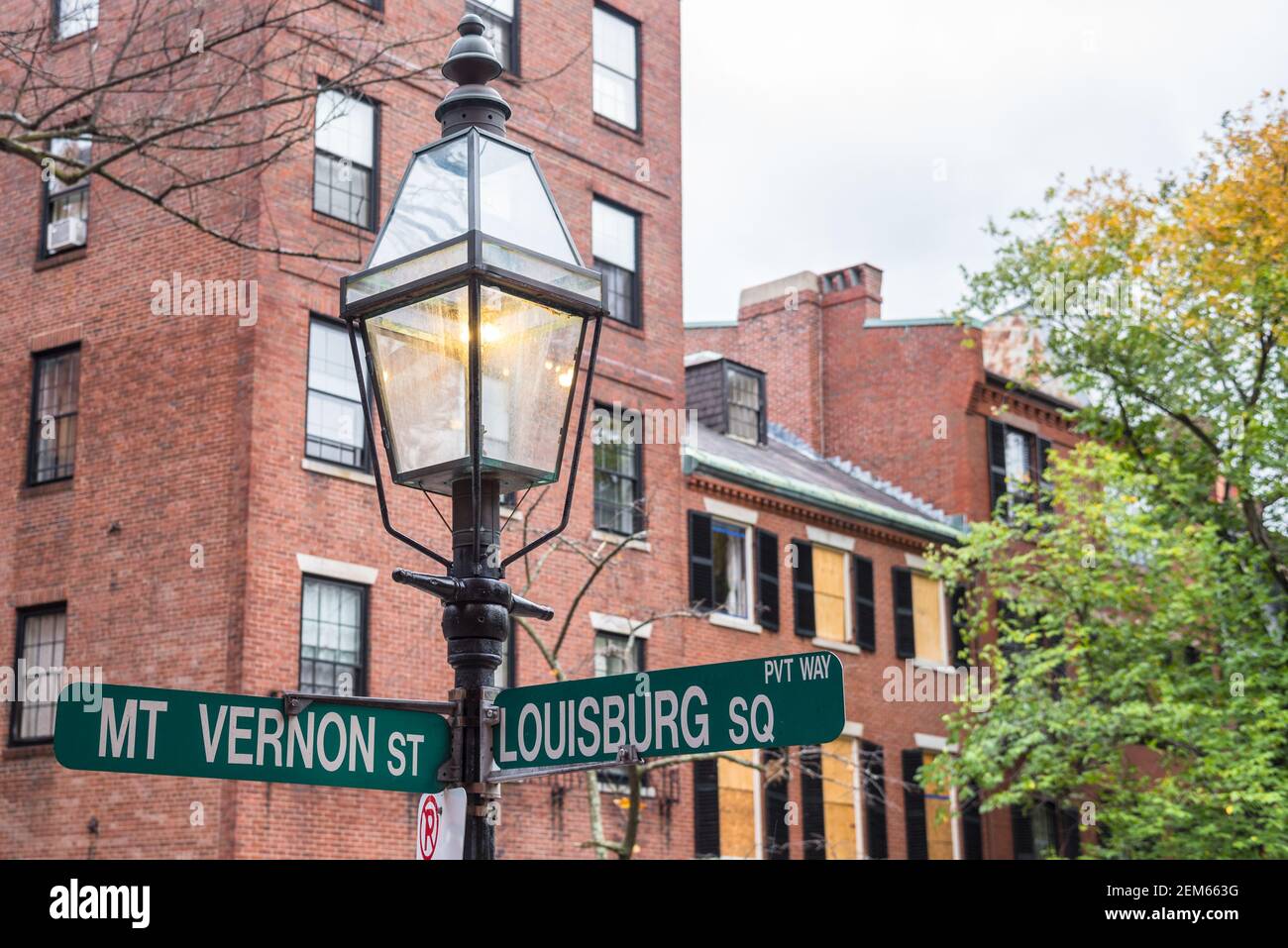 Primo piano di una lampada a gas tradizionale con Cartelli stradali nel quartiere storico di Beacon Hill in Centro di Boston Foto Stock