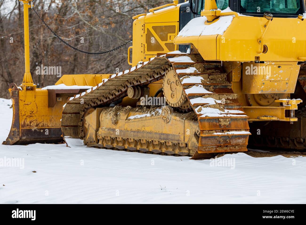 Bulldozer in cantiere dopo la tempesta di neve invernale. Concetto di edilizia, ritardo del lavoro e arresto. Foto Stock
