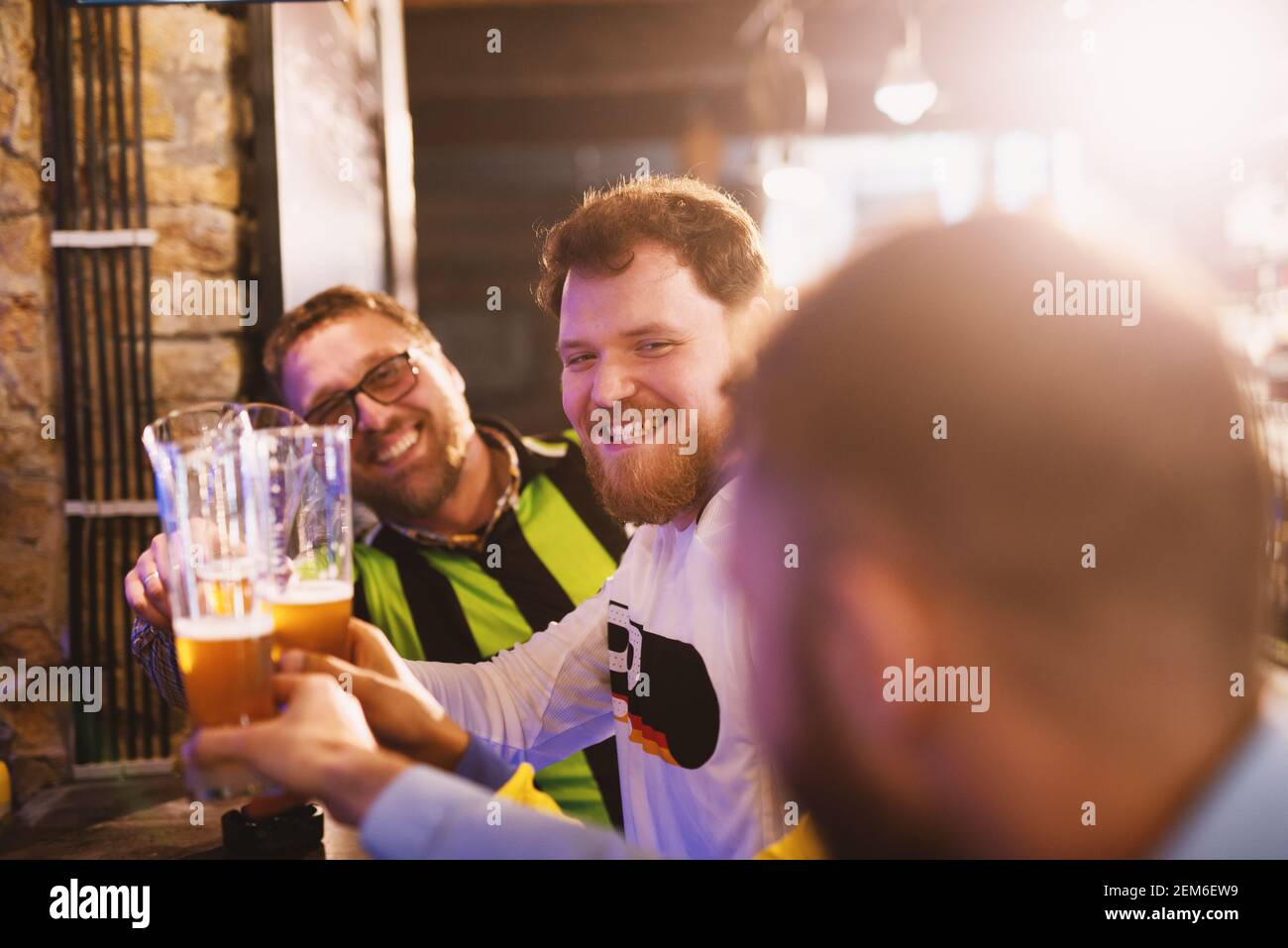 Gli appassionati di calcio si salutano con le pinte di birra nel loro pub preferito. Foto Stock