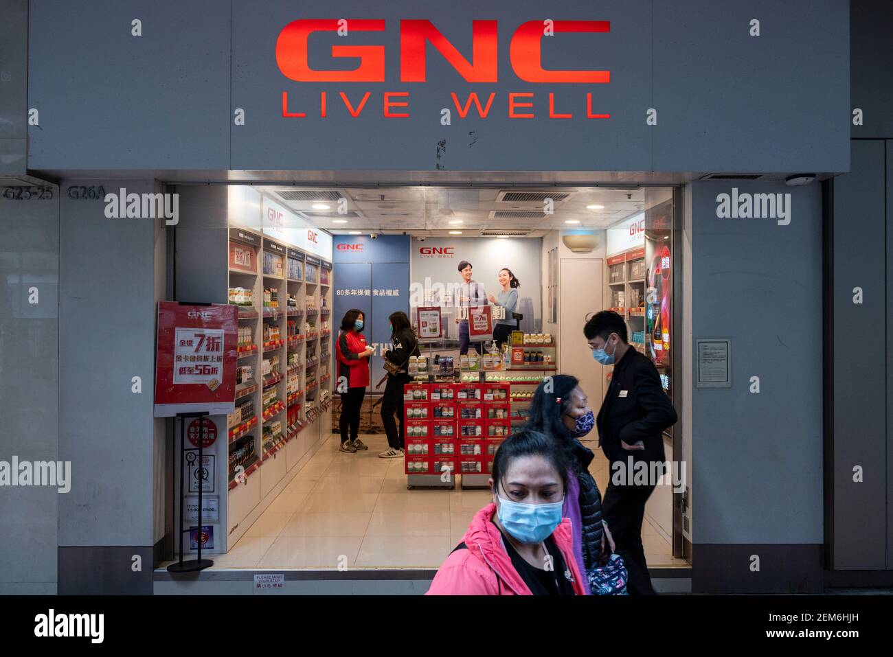 Hong Kong, Cina. 24 Feb 2021. I pedoni passano oltre i prodotti di marca relativi alla salute e alla nutrizione, il deposito dei centri di nutrizione generali (GNC) visto a Hong Kong. Credit: SOPA Images Limited/Alamy Live News Foto Stock