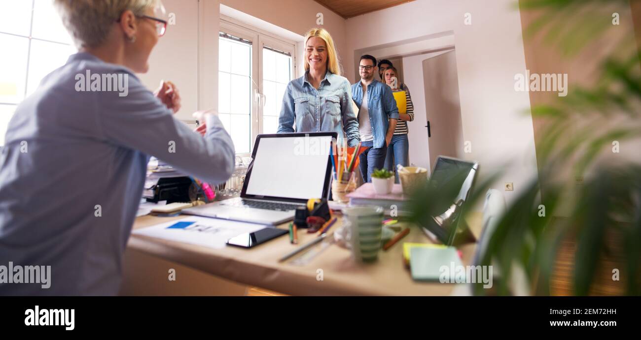 Gruppo di giovani ingegneri felici è stato informato che hanno ottenuto il lavoro quando entrano nell'ufficio del loro nuovo capo. Foto Stock