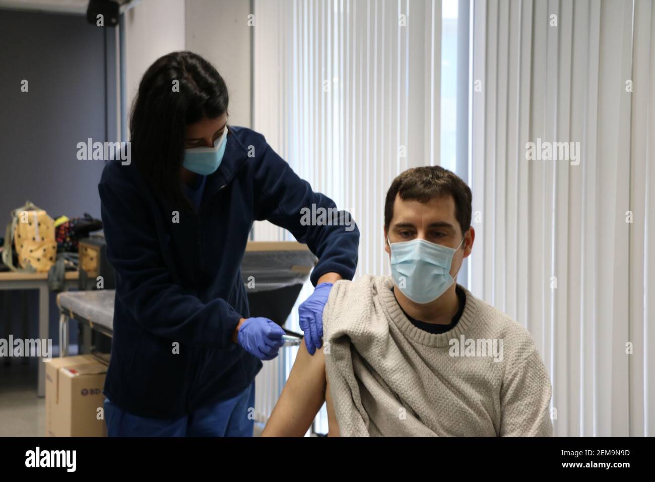 Barcellona. 24 Feb 2021. Un collaboratore riceve una dose di vaccino COVID-19 presso la Facoltà di Geografia e Storia dell'Università di Barcellona, in Spagna, il 24 febbraio 2021. La campagna di vaccinazione per il personale educativo in Catalogna è iniziata questa settimana. Credit: Ismael Peracaula/Xinhua/Alamy Live News Foto Stock