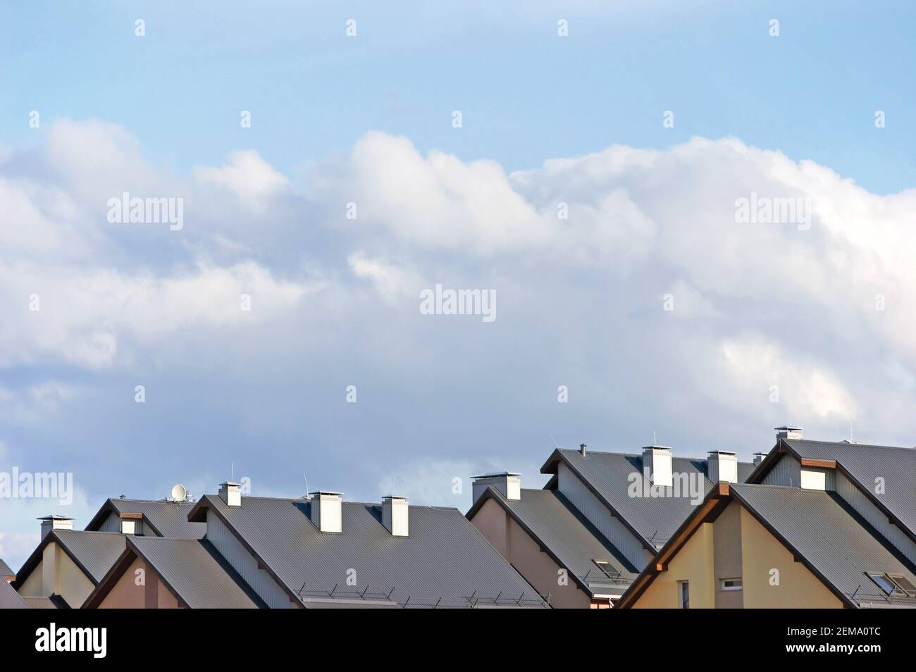 Tetti di casa a schiera, grande paesaggio panoramico dettagliato, panorama di dettaglio tetto della casa a schiera condominiale, condomini multipli, azzurro luminoso paesaggio di nuvole d'estate, cielo soleggiato Foto Stock