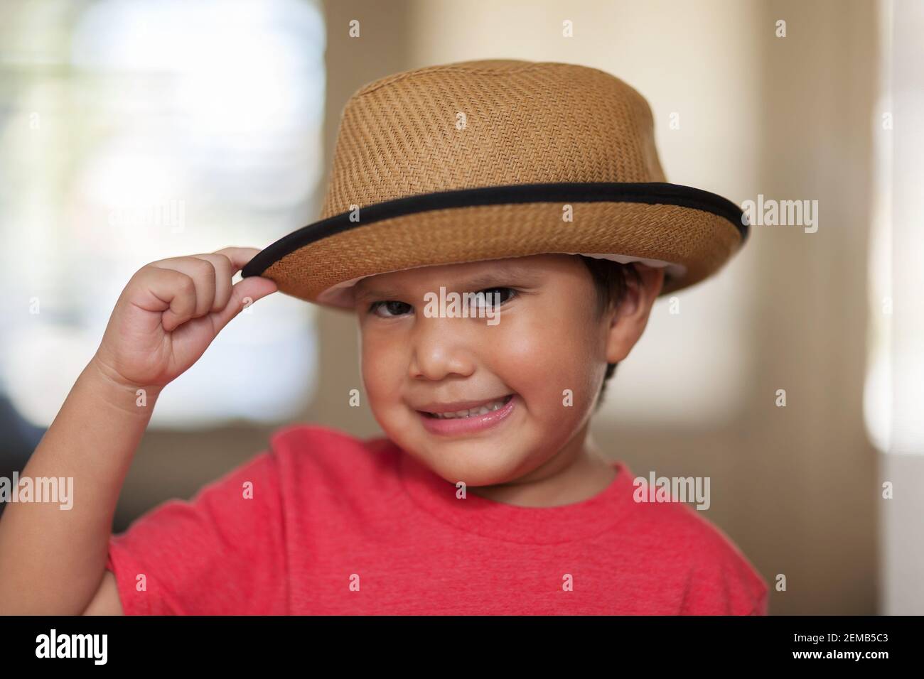 Bambino di quattro anni imparando a dare il cappello come un gesto di gentilezza. Foto Stock