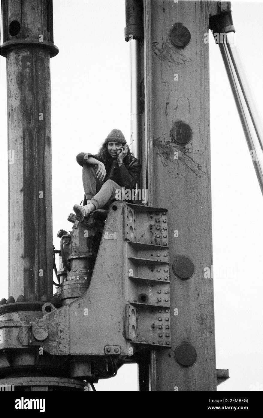 Un protestore che occupa una macchina di palificazione su un cantiere come parte delle proteste contro la M11 link Road a East London, 1994 Foto Stock