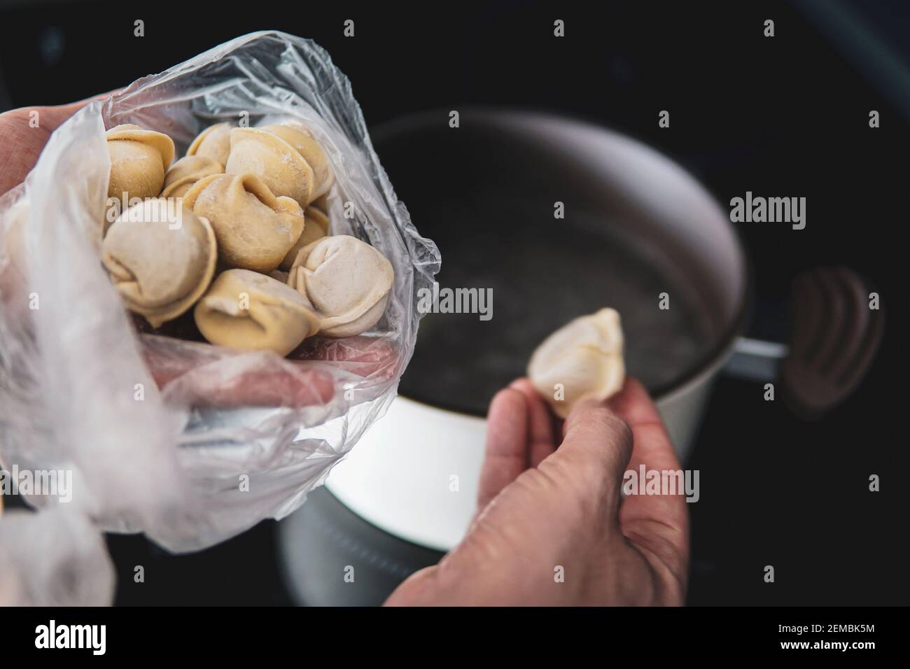 I gnocchi dell'impasto con carne vengono bolliti in acqua bollente. Foto del cibo. Il piatto culinario gnocchi ucraini. Foto Stock