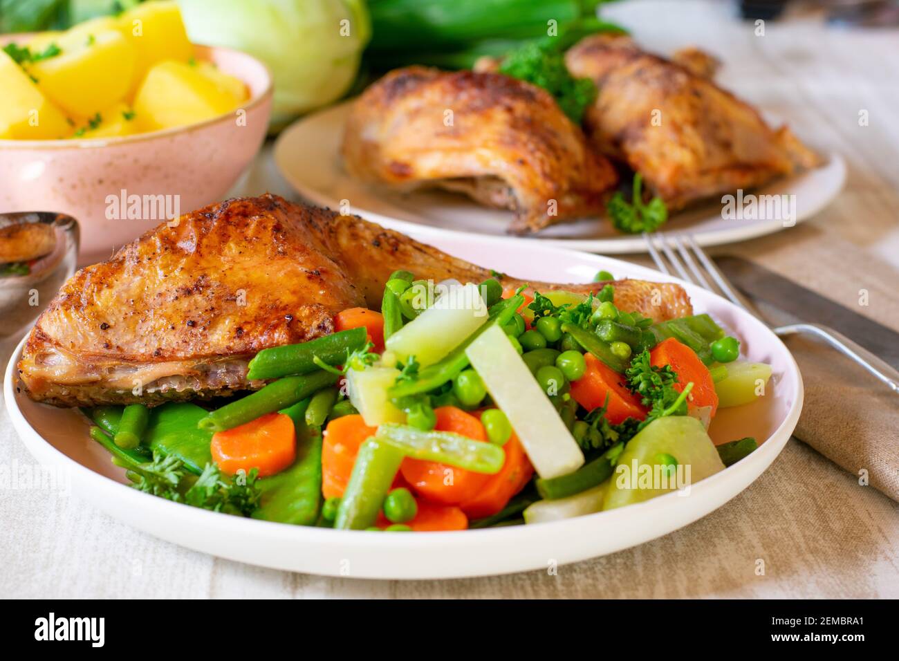 verdure di primavera fresche cotte su un piatto con pollo Foto Stock