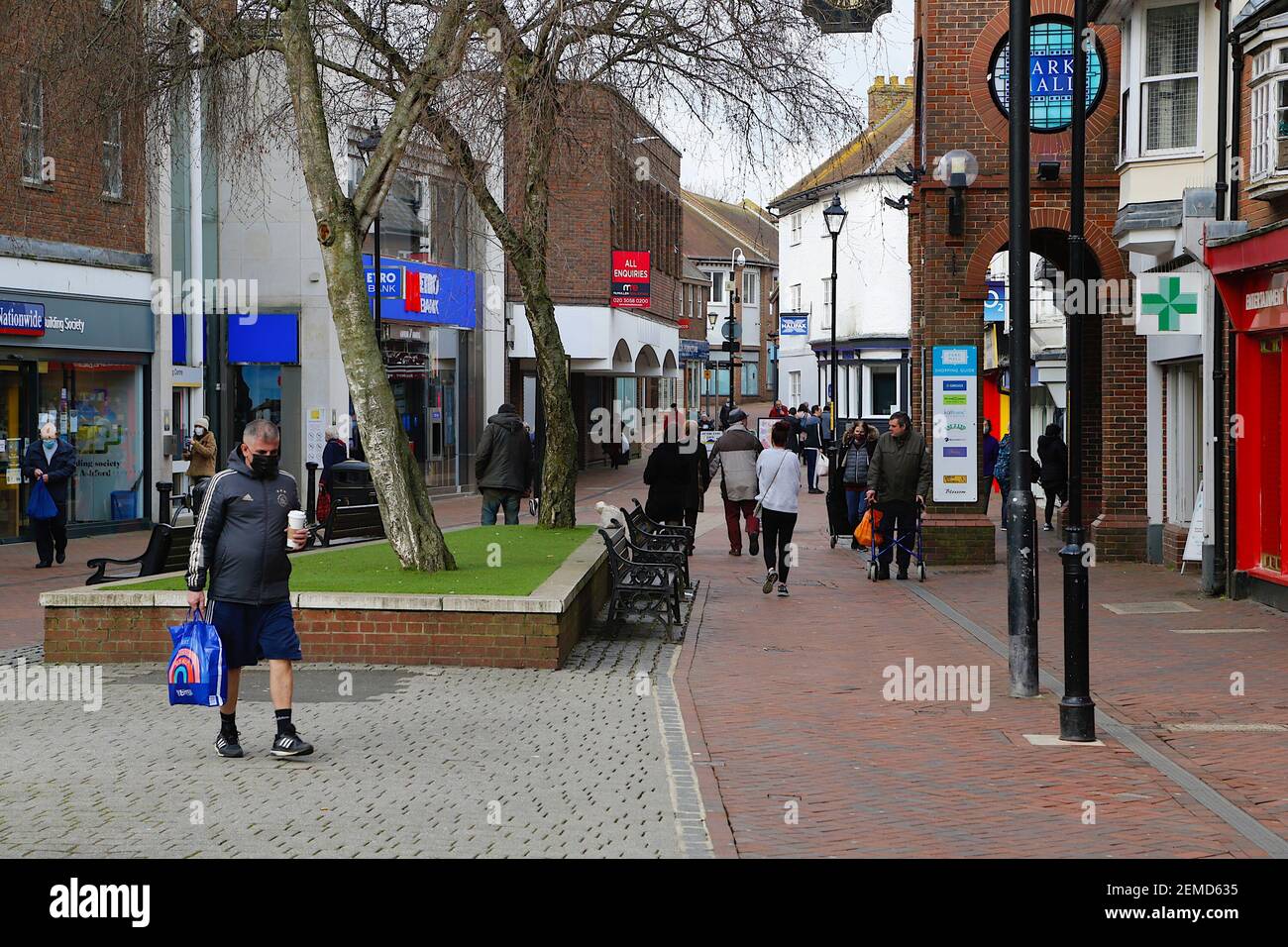 Ashford, Kent, Regno Unito. 25 febbraio 2021. I casi settimanali del coronavirus sono diminuiti considerevolmente ad Ashford con 71.5 casi per 100,000 popolazione. Persone che indossano maschere durante il blocco 3 nel centro della città alta strada. Photo Credit: Paul Lawrenson/Alamy Live News Foto Stock