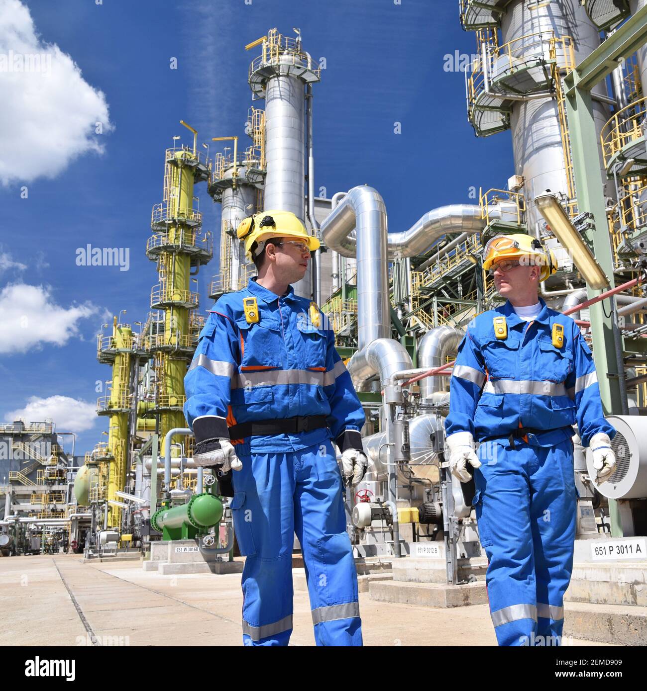 gruppo di lavoratori industriali in una raffineria - macchine e attrezzature per la lavorazione del petrolio Foto Stock