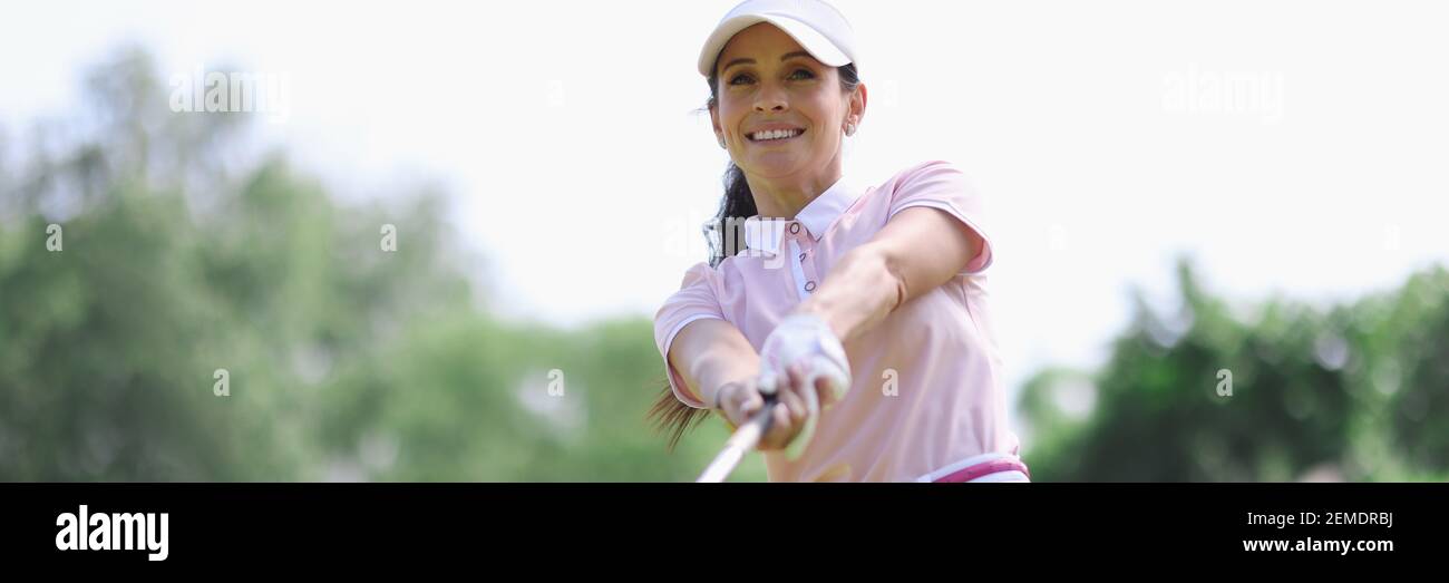 Donna golfer con putter in mano dopo aver colpito. Foto Stock