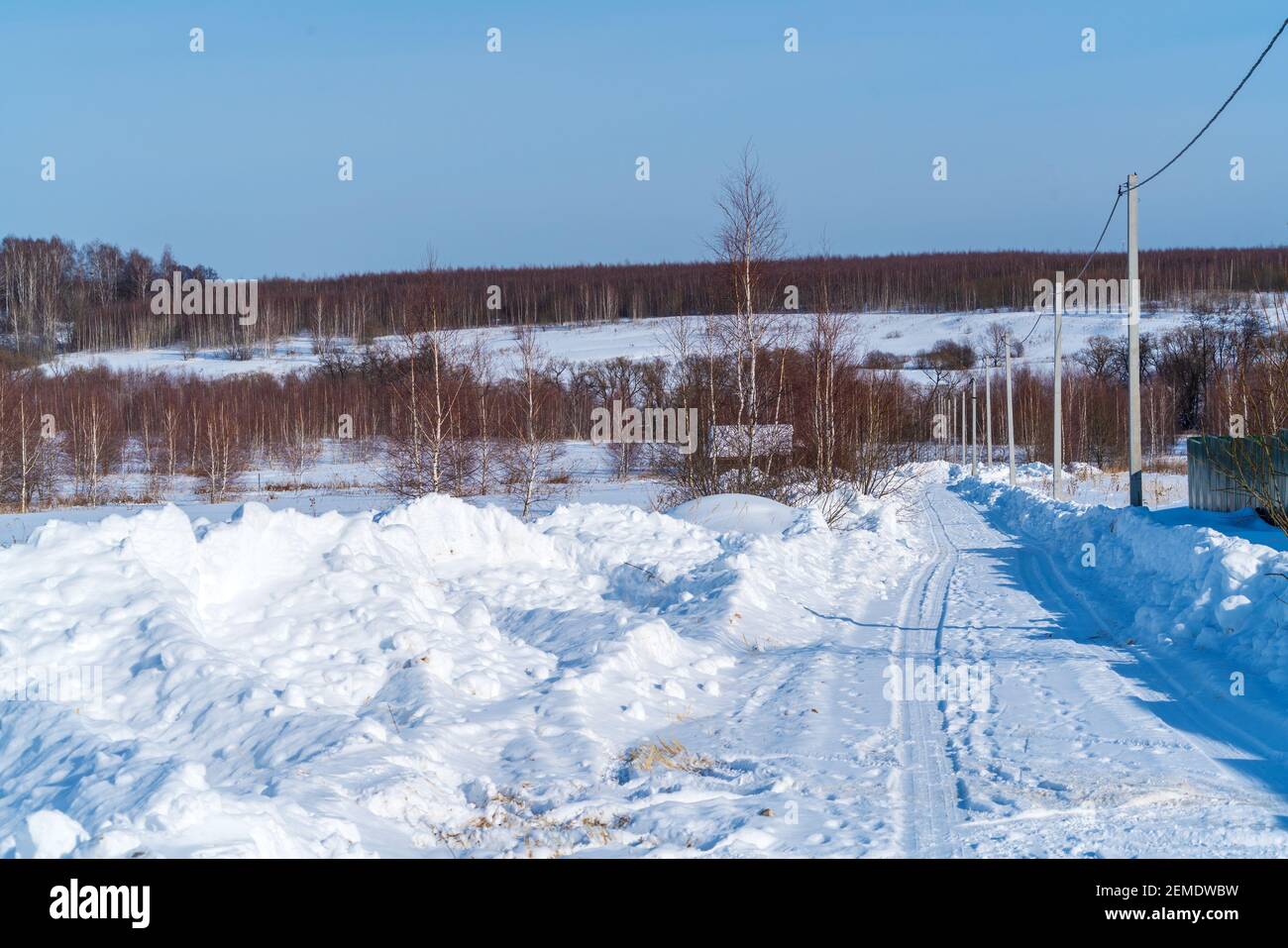 Enormi mucchi di neve dopo il lavoro di un trattore per liberare strade rurali in inverno le conseguenze di pesanti nevicata Foto Stock