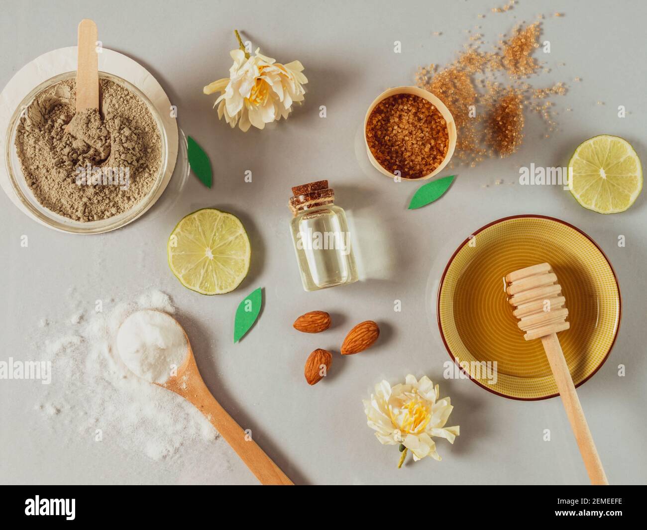 prodotti naturali per la cura della pelle: bicarbonato di sodio, polvere di argilla, zucchero di canna, olio di mandorle. Sfondo colorato di cosmetici naturali e fiori. Ingredienti naturali Foto Stock