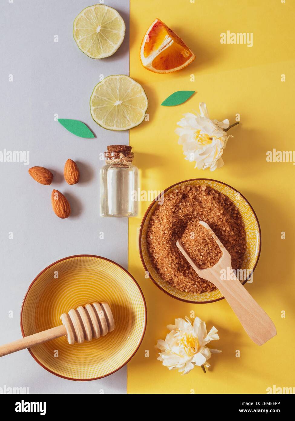 prodotti naturali per la cura della pelle: soda di supporto, miele, zucchero di canna, olio di mandorle. Sfondo colorato di cosmetici naturali e fiori. Ingredienti naturali per Foto Stock