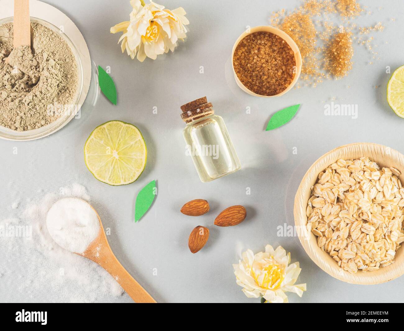 prodotti naturali per la cura della pelle: miele, polvere di argilla, zucchero di canna, olio di mandorle, avena. Sfondo colorato di cosmetici naturali e fiori. Ingredienti naturali Foto Stock