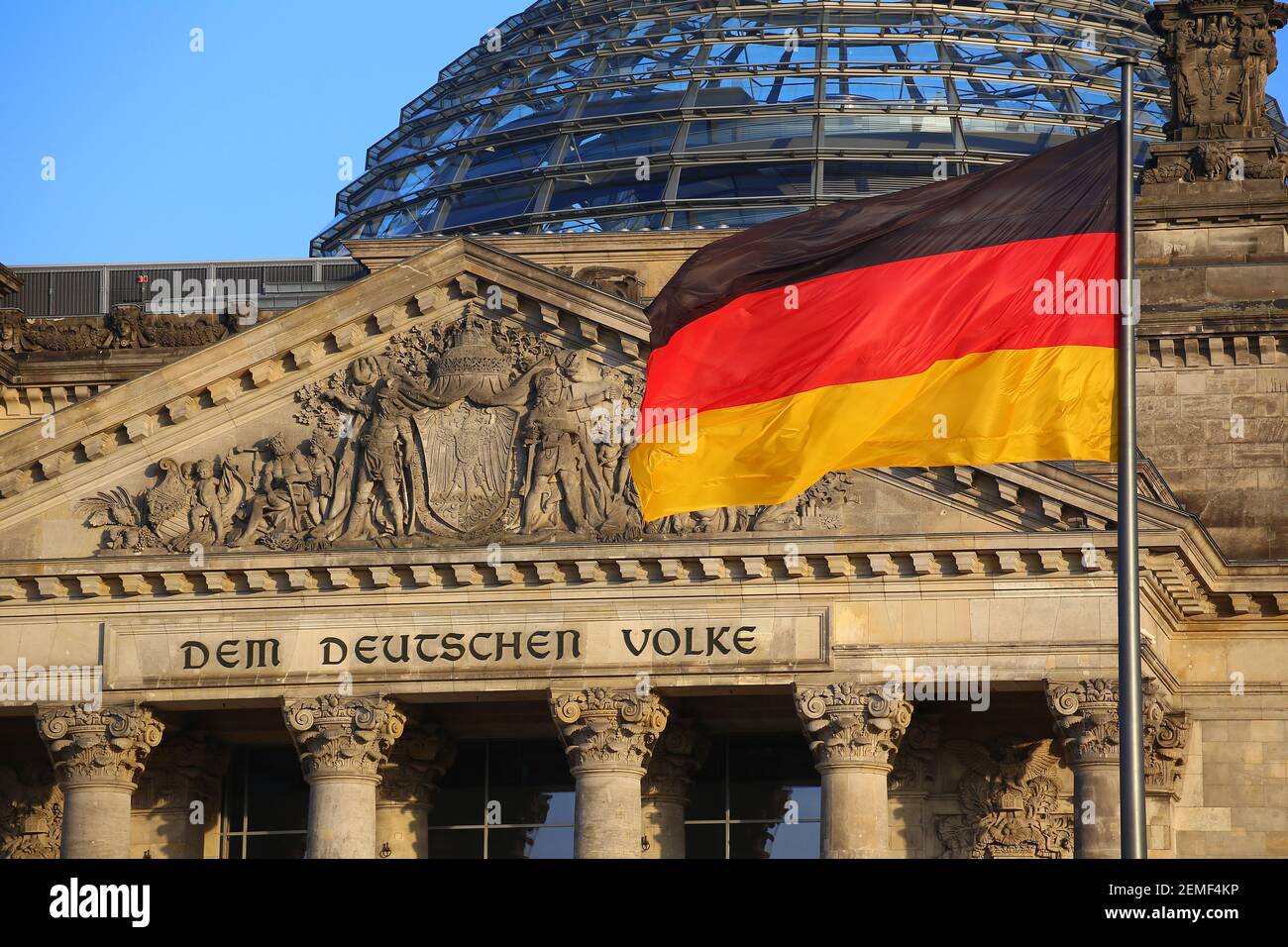 La bandiera tedesca di fronte all'edificio del Reichstag a Berlino. L'iscrizione dice: DEM Deutschen Volke - al popolo tedesco. Foto Stock