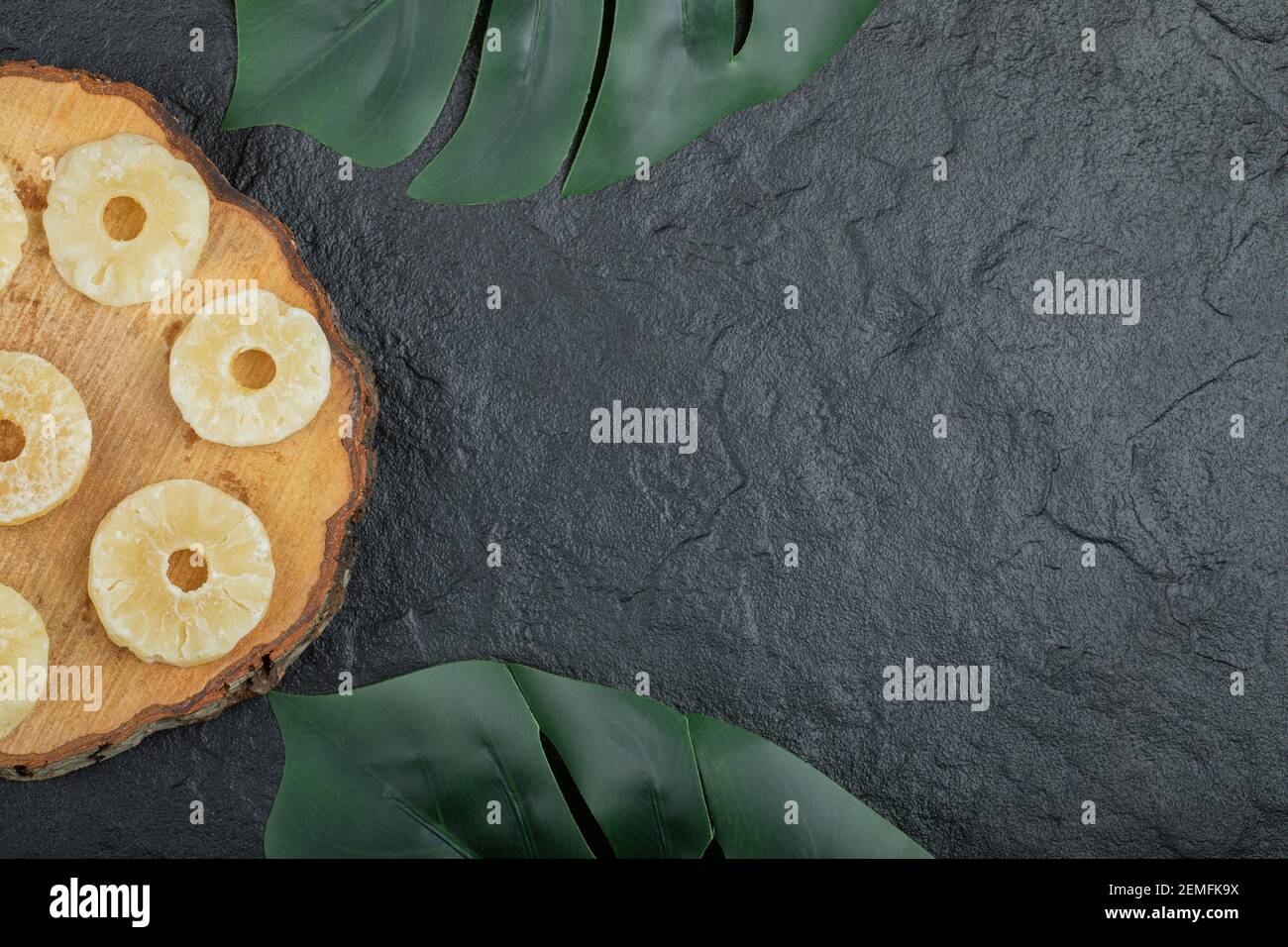 Anelli di ananas essiccati su pezzo di legno Foto Stock