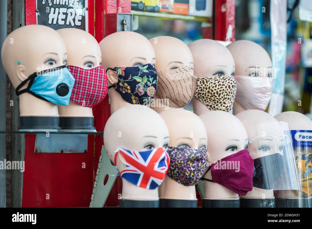 Londra, UK - 5 Febbraio, 2021 - maschere facciali in tessuto con vari modelli esposti su teste manichino in vendita su Wood Green High Street Foto Stock
