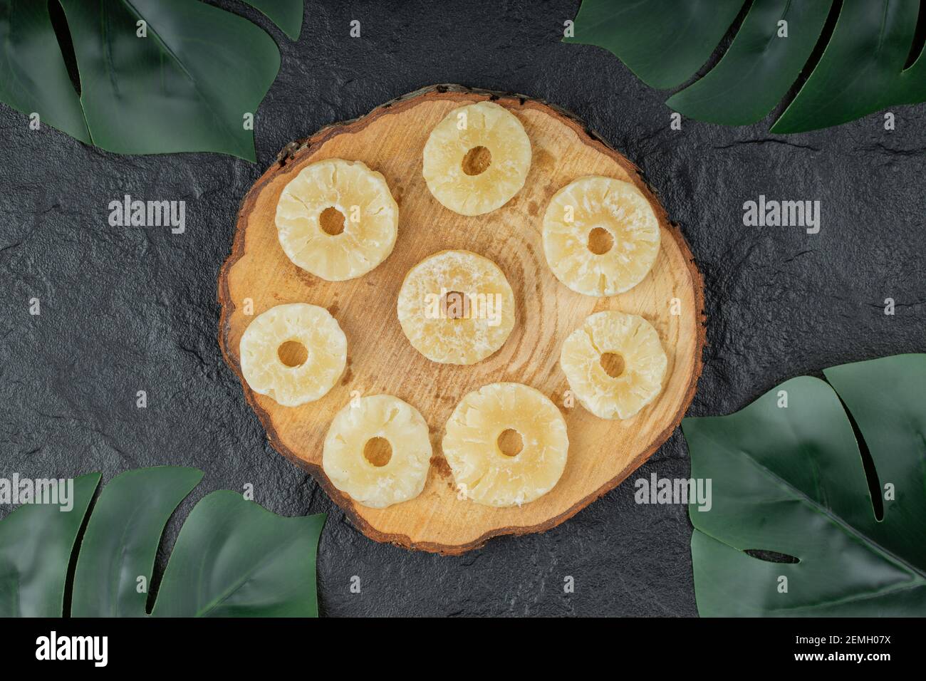 Anelli di ananas essiccati su pezzo di legno Foto Stock