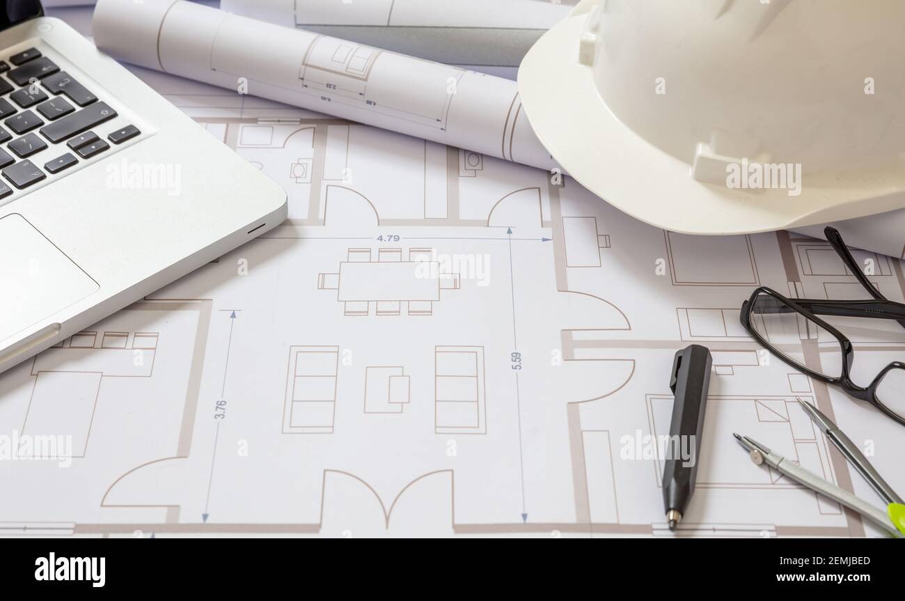 Progetto Blueprints laptop e tecnico hardhat colore bianco su sfondo disegni. Progetto di costruzione di alloggi, progetto di architetto ufficio. Foto Stock
