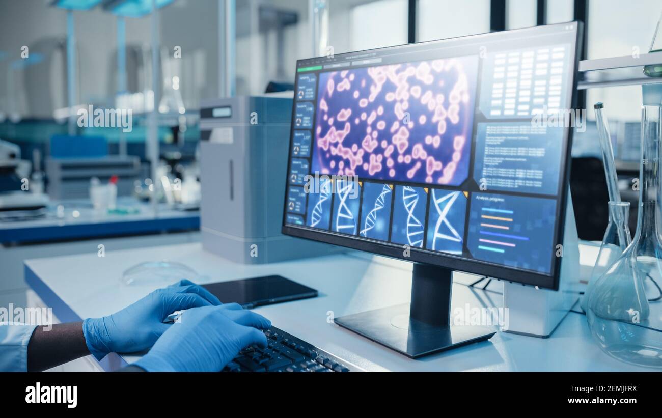 Modern Medical Research Laboratory: Ritratto di scienziato maschile che lavora su computer mostrando il concetto di DNA. Laboratorio scientifico e sviluppo di Medicina Foto Stock