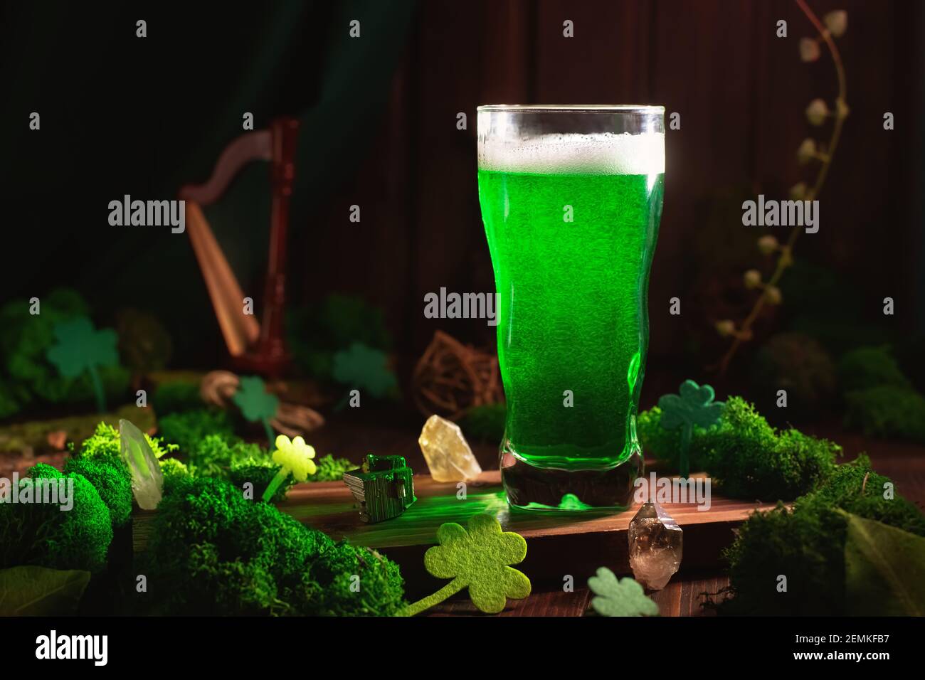 San Patrizio's Day birra verde pinta su sfondo di legno, con foglie di shamrock, arpa. Festa del pub Patrick Day, festeggiando. Primo piano con un bicchiere di birra verde Foto Stock