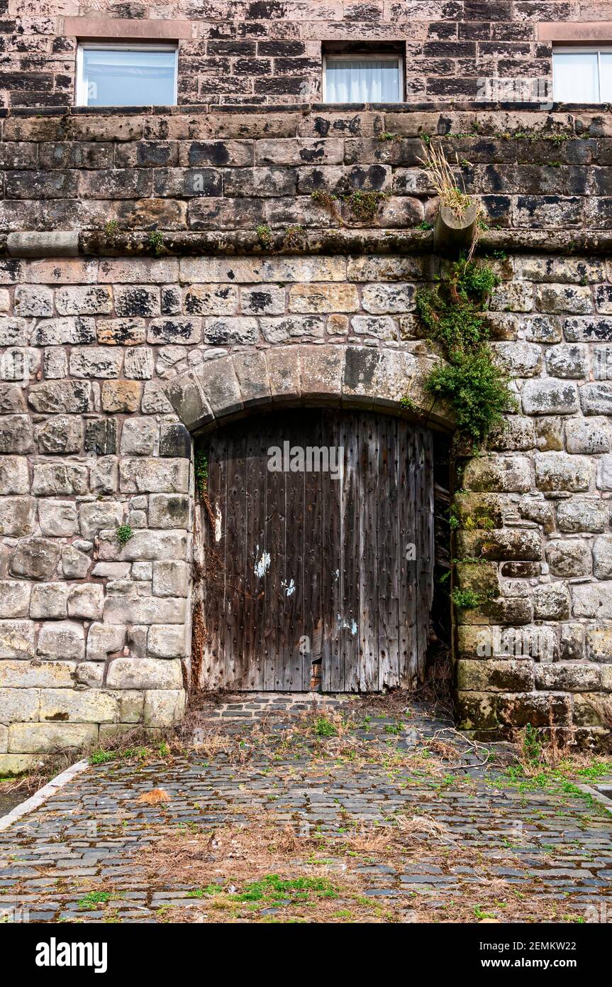 Una vecchia casa personalizzata si erge in cima all'antica mura di quay che hanno chiuso porte chiodate ad un passaggio Attraverso l'altro lato a Berwick sopra Foto Stock