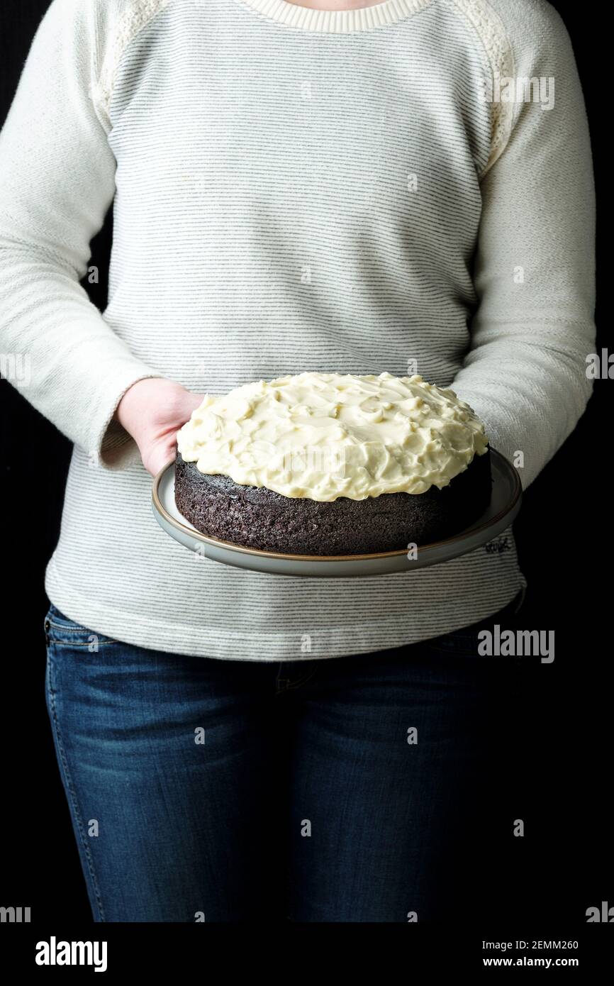 Una donna presenta una torta di cioccolato e Guinness Nigella Lawson appena sfornata. La cottura è stata un'attività di blocco popolare durante l'epidemia di COVID Foto Stock