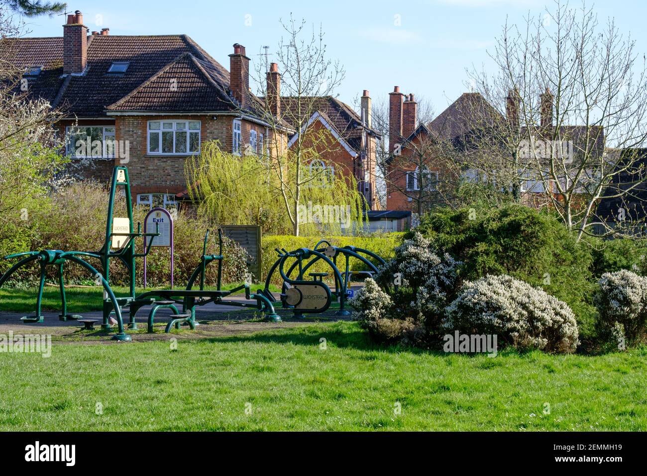 Palestra esterna circondata da alberi, erba e arbusti con case sullo sfondo. Pinner Memorial Park, Pinner, Harrow, Londra. Foto Stock