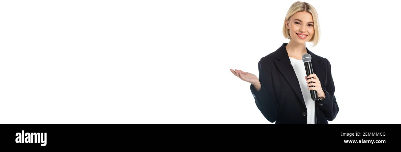 buon emittente bionda con microfono puntato con mano isolata su bianco, banner Foto Stock